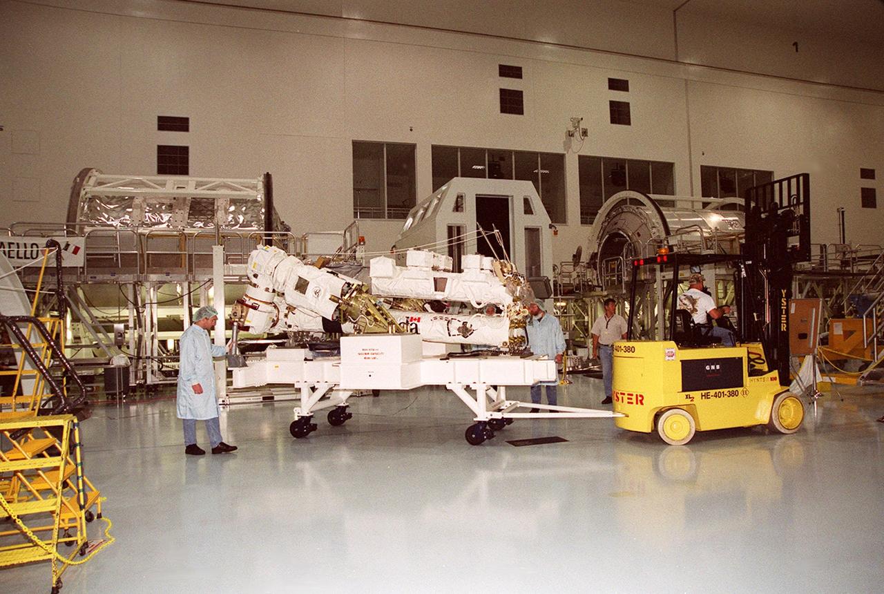 Workers in the Space Station Processing Facility move the Space Station Remote Manipulator System (SSRMS), also known as the “Canadian arm,” to a pallet for testing. The SSRMS is part of Canada’s Mobile Servicing System, an essential component of the International Space Station. This robotic system will play a key role in Space Station assembly and maintenance, moving equipment and supplies around the Station, releasing and capturing satellites, supporting astronauts working in space and servicing instruments and other payloads attached to the Space Station. SSRMS will be on Shuttle mission STS-100, flight 6A, to the Space Station, scheduled for launch April 19, 2001