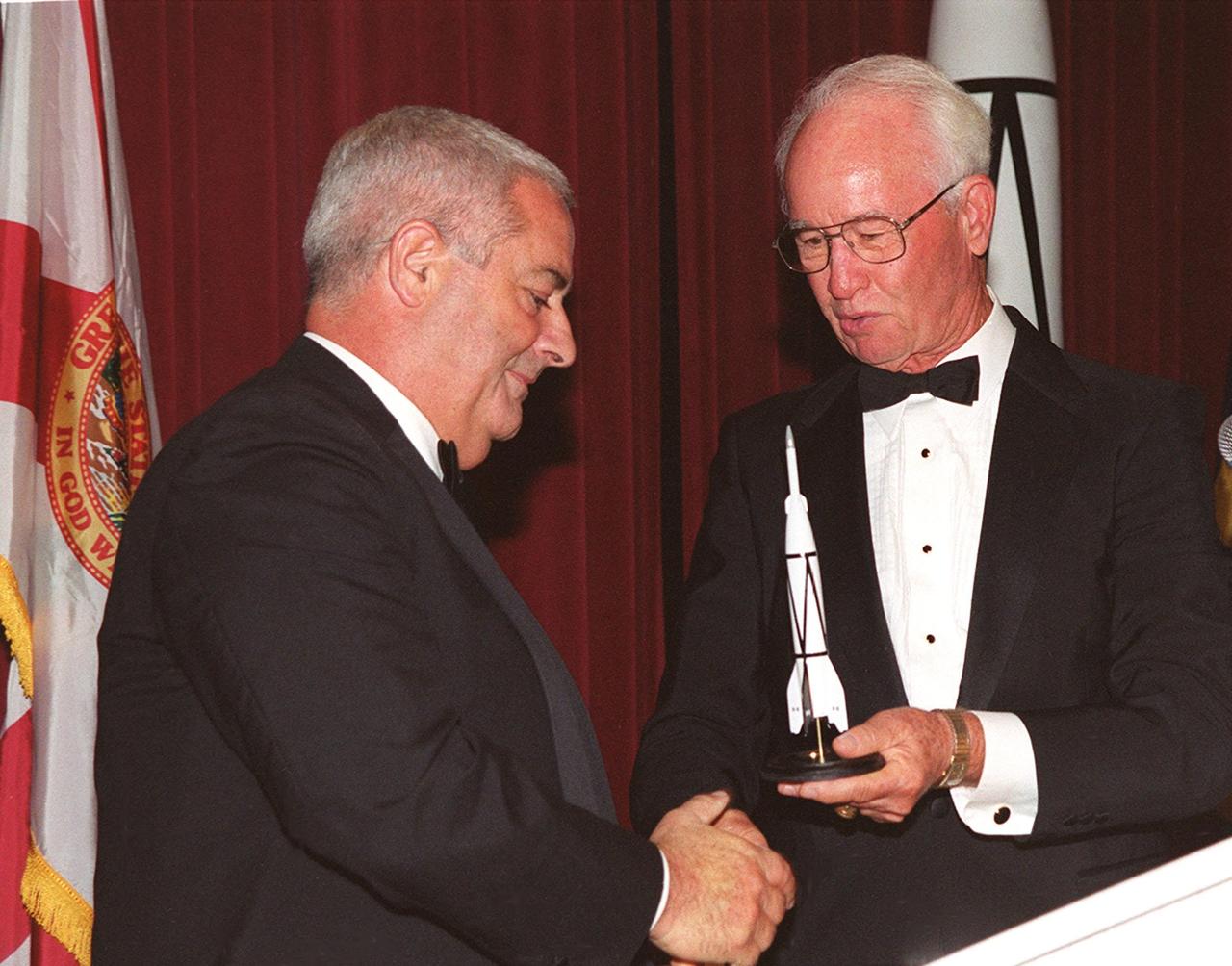 At a 50<sup>th</sup> anniversary gala capping a year-long celebration of 50 years of rocket launches from Cape Canaveral Air Force Station, Chris Bailey (left), president of the AFA Cape Canaveral Chapter, receives a rocket model from Maxwell King (right), former president of Brevard Community College. The first launch at CCAFS took place at 9:28 a.m. on July 24, 1950, with the liftoff of Bumper 8 from Launch Complex 3. The gala, hosted by the Cape Canaveral Chapter Air Force Association, featured such speakers as Center Director Roy Bridges; Vice Commander, Air Force Space Command, Lt. Gen. Roger DeKok; and the Honorable David Weldon, U.S. representative of Florida’s 15<sup>th</sup> Congressional District