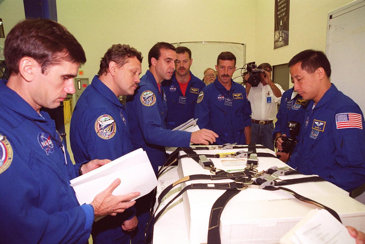 KENNEDY SPACE CENTER, FLA. -- During Crew Equipment Interface Test activities, the STS-106 crew check equipment at SPACEHAB that they will be using on their mission. From left are Mission Specialists Yuri I. Malenchenko, Boris V. Morukov and Richard A. Mastracchio, Pilot Scott D. Altman, and Mission Specialists Daniel C. Burbank and Edward T. Lu. Malenchenko and Morukov represent the Russian Aviation and Space Agency. STS-106 is scheduled to launch Sept. 8, 2000, at 8:31 a.m. EDT from Launch Pad 39B on an 11-day mission to the International Space Station. The seven-member crew will prepare the Space Station for its first resident crew and begin outfitting the newly arrived Zvezda Service Module. They will perform support tasks on orbit, transfer supplies and prepare the Zvezda living quarters for the first long-duration crew, dubbed “Expedition One,” which is due to arrive at the Station in late fall
