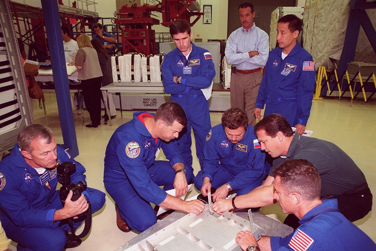KENNEDY SPACE CENTER, FLA. -- At SPACEHAB members of the STS-106 crew check out equipment they will be using during their mission to the International Space Station. From left are Commander Terrence W. Wilcutt, Pilot Scott D. Altman, and Mission Specialists Yuri I. Malenchenko (standing), Boris V. Morukov, Edward T. Lu (also standing), and (in the foreground, right) Daniel C. Burbank. Malenchenko and Morukov represent the Russian Aviation and Space Agency. STS-106 is scheduled to launch Sept. 8, 2000, at 8:31 a.m. EDT from Launch Pad 39B on an 11-day mission. The seven-member crew will prepare the Space Station for its first resident crew and begin outfitting the newly arrived Zvezda Service Module. They will perform support tasks on orbit, transfer supplies and prepare the Zvezda living quarters for the first long-duration crew, dubbed “Expedition One,” which is due to arrive at the Station in late fall