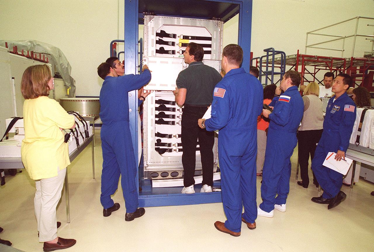 KENNEDY SPACE CENTER, FLA. -- As part of Crew Equipment Interface Test (CEIT) activities at SPACEHAB, members of the STS-106 crew check out a Maximum Envelope Support Structure (MESS) rack they will be using during their mission to the International Space Station. Seen here (with backs to camera, in uniform) are Mission Specialist Richard A. Mastracchio, Pilot Scott D. Altman, Boris V. Morukov, and Edward T. Lu (at right). Also taking part in the CEIT are Commander Terrence W. Wilcutt and Mission Specialists Yuri I. Malenchenko and Daniel C. Burbank. Malenchenko and Morukov represent the Russian Aviation and Space Agency. STS-106 is scheduled to launch Sept. 8, 2000, at 8:31 a.m. EDT from Launch Pad 39B on an 11-day mission. The seven-member crew will prepare the Space Station for its first resident crew and begin outfitting the newly arrived Zvezda Service Module. They will perform support tasks on orbit, transfer supplies and prepare the Zvezda living quarters for the first long-duration crew, dubbed “Expedition One,” which is due to arrive at the Station in late fall