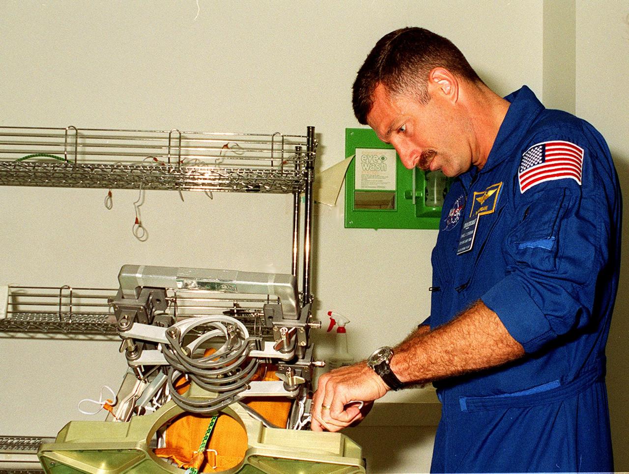 STS-106 Mission Specialist Daniel C. Burbank checks out a Russian foot restraint at SPACEHAB, part of the payload on the mission to the International Space Station. He and the other crew members Commander Terrence W. Wilcutt, Pilot Scott D. Altman, and Mission Specialists Edward T. Lu, Yuri I. Malenchenko, Boris V. Morukov and Richard A. Mastracchio are taking part in Crew Equipment Interface Test (CEIT) activities at SPACEHAB. Malenchenko and Morukov represent the Russian Aviation and Space Agency. On the 11-day mission, the seven-member crew will perform support tasks on orbit, transfer supplies and prepare the living quarters in the newly arrived Zvezda Service Module for the first long-duration crew, dubbed “Expedition One,” which is due to arrive at the Station in late fall. STS-106 is scheduled to launch Sept. 8, 2000, at 8:31 a.m. EDT from Launch Pad 39B
