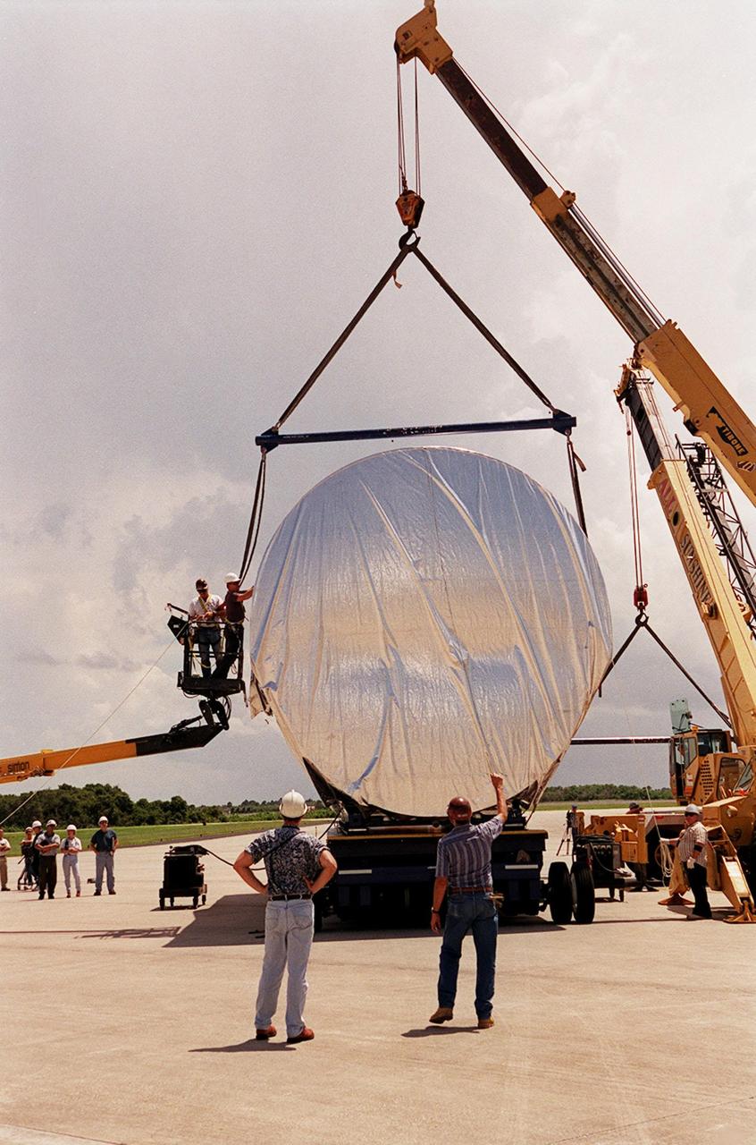 Workers oversee the placement of the P-1 truss, a component of the International Space Station, onto a flatbed truck that will move it to the Operations and Checkout Building for processing. The P-1 truss, scheduled to fly in spring of 2002, is part of a total 10-truss, girder-like structure on the Station that will ultimately extend the length of a football field. Astronauts will attach the 14-by-15 foot structure to the port side of the center truss, S0, during the spring assembly flight. The 33,000-pound P-1 will house the thermal radiator rotating joint (TRRJ) that will rotate the Station’s radiators away from the sun to increase their maximum cooling efficiency