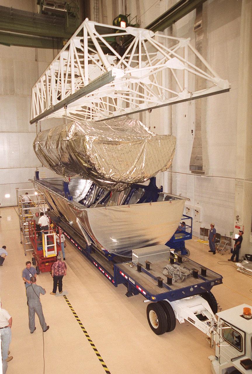 Inside the Operations and Checkout Building, the P-1 truss, a component of the International Space Station, is lifted out of its canister to move to a work stand where it will undergo processing. Scheduled to fly in spring of 2002, the P-1 is part of a total 10-truss, girder-like structure on the Station that will ultimately extend the length of a football field. Astronauts will attach the 14-by-15 foot structure to the port side of the center truss, S0, during the spring assembly flight. The 33,000-pound P-1 will house the thermal radiator rotating joint (TRRJ) that will rotate the Station’s radiators away from the sun to increase their maximum cooling efficiency