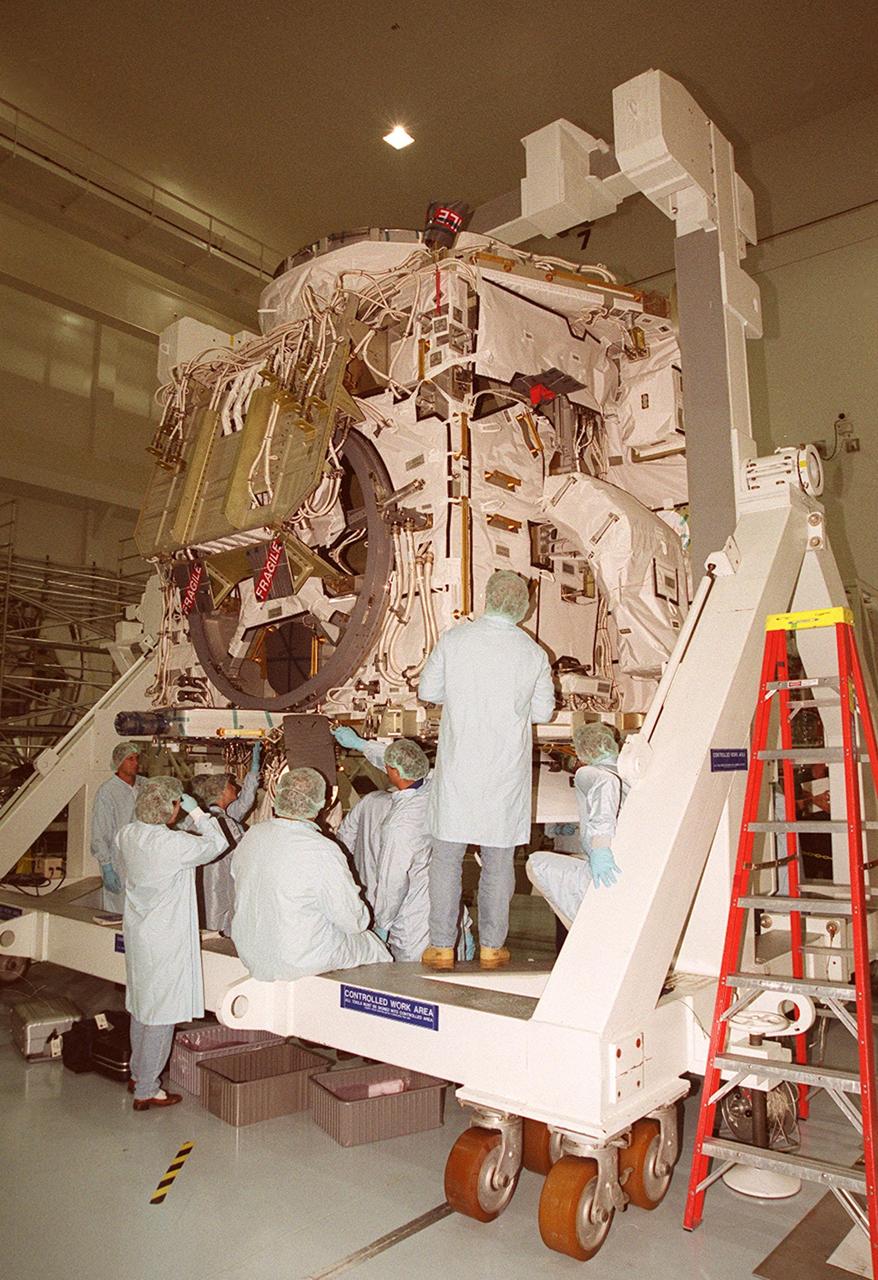The STS-92 astronaut team study the the Zenith-1 (Z-1) Truss during the Crew Equipment Interface Test. The Z-1 Truss was officially presented to NASA by The Boeing Co. on the Space Station Processing Facility floor on July 31. The truss is the cornerstone truss of the International Space Station and is scheduled to fly in Space Shuttle Discovery's payload pay on STS-92 targeted for launch Oct. 5, 2000. The Z-1 is considered a cornerstone truss because it carries critical components of the Station's attitude, communications, thermal and power control systems as well as four control moment gyros, high and low gain antenna systems, and two plasma contactor units used to disperse electrical charge build-ups. The Z-1 truss and a Pressurized Mating Adapter (PMA-3), also flying to the Station on the same mission, will be the first major U.S. elements flown to the ISS aboard the Shuttle since the launch of the Unity element in December 1998