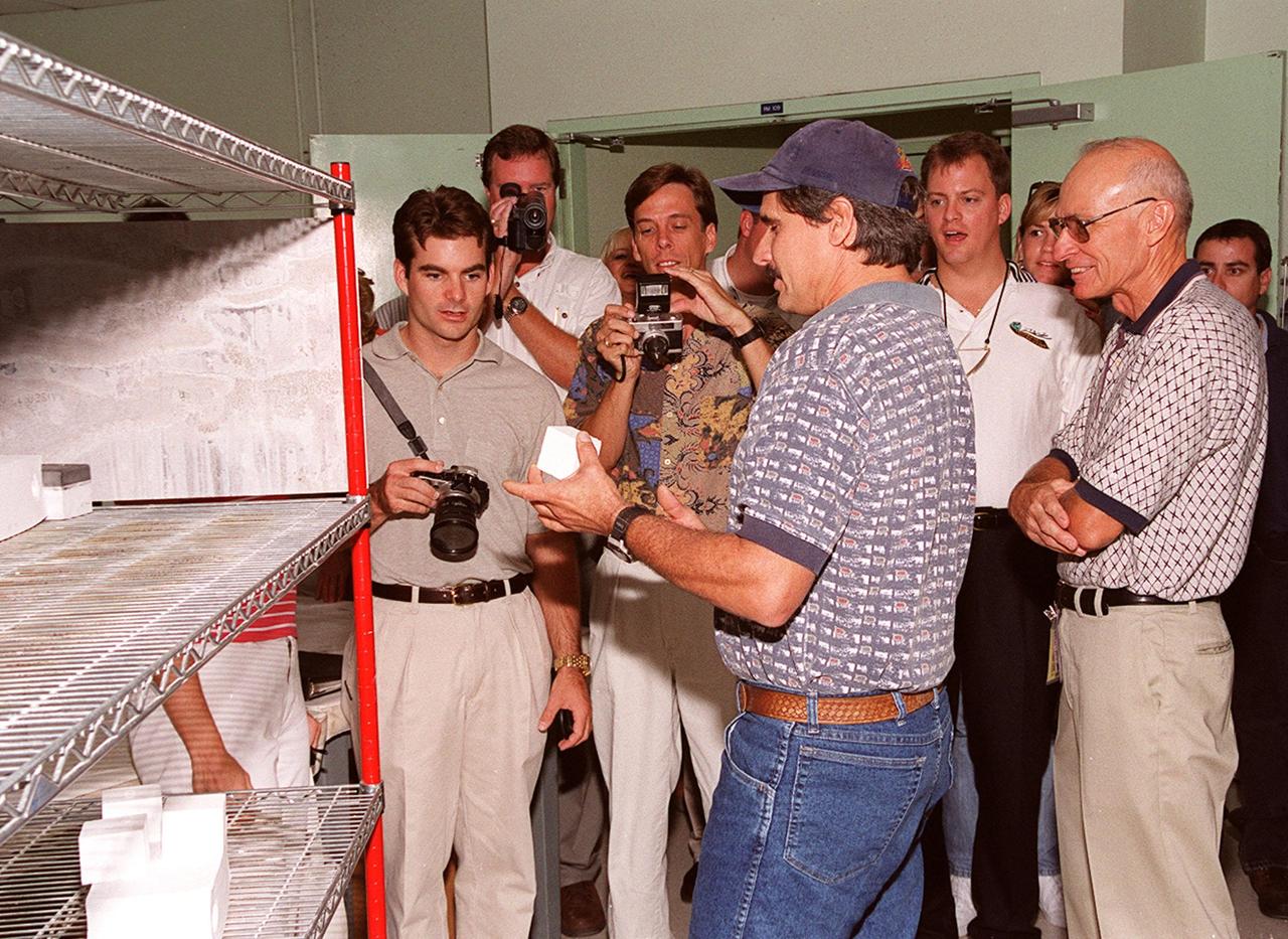 KENNEDY SPACE CENTER, FLA. -- During a visit to KSC, NASCAR race driver Jeff Gordon (left) looks at a tile in the Tile Shop in the Launch Complex 39 area. Former KSC launch director Bob Sieck (far right) looks on