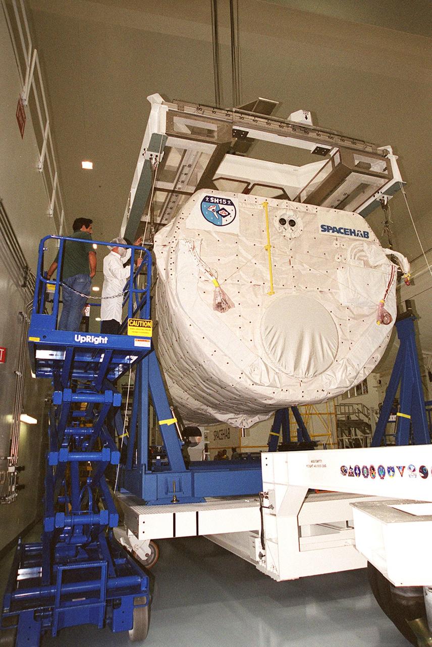 KENNEDY SPACE CENTER, FLA. --  Workers attach an overhead crane to the SPACEHAB module to lift it off the transport vehicle beneath it. The module, part of the payload on mission STS-106, will be placed in the payload canister for transport to the launch pad. STS-106 is scheduled to launch Sept. 8 at 8:31 a.m. EDT