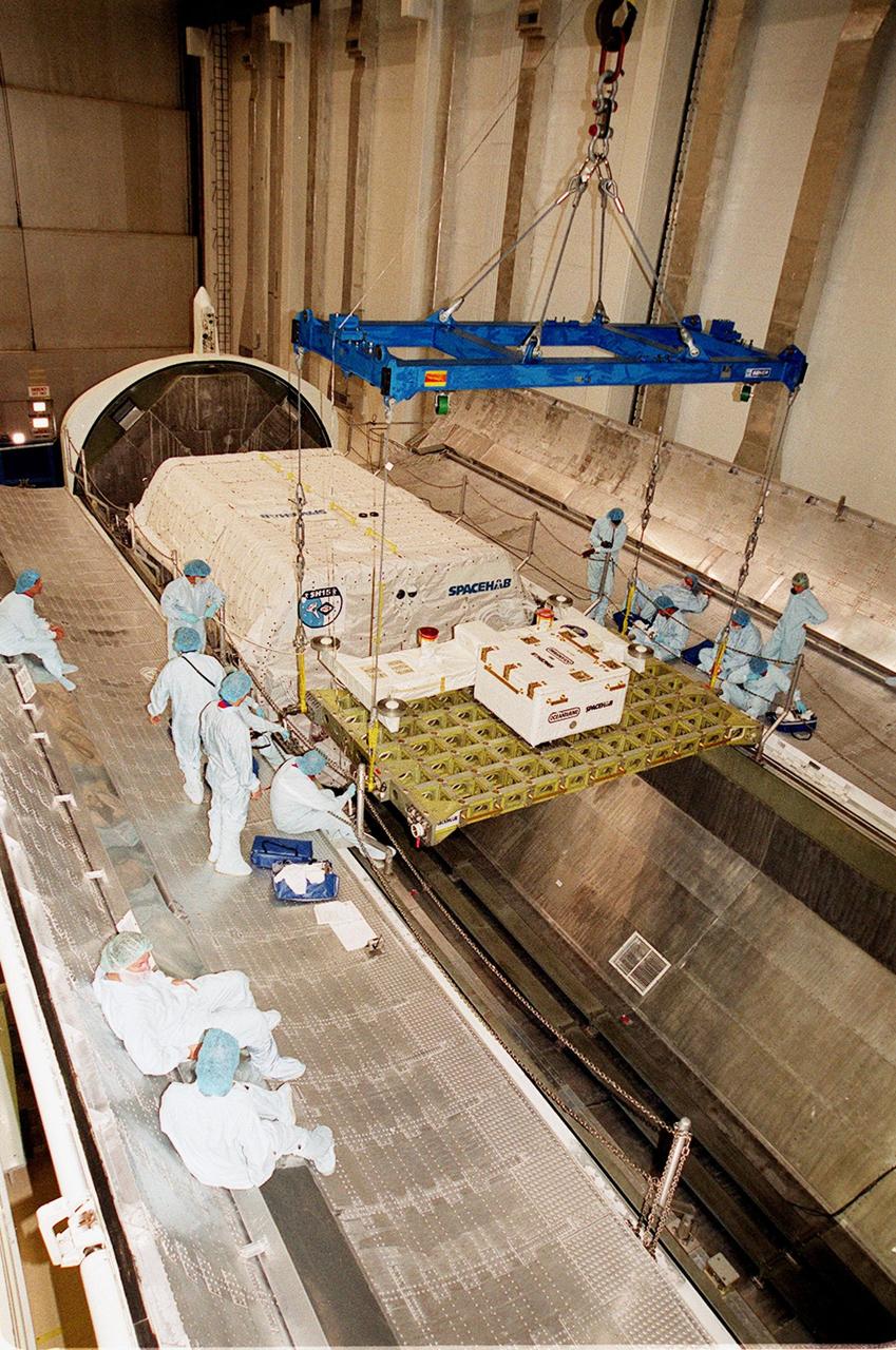 KENNEDY SPACE CENTER, FLA. -- Workers in the Space Station Processing Facility guide the Integrated Cargo Carrier (ICC) into place inside the payload canister. The canister already has the SPACEHAB module stowed. The canister will transport its cargo to Launch Pad 39B in preparation for mission STS-106, scheduled to launch Sept. 8 at 8:31 a.m. EDT. During the mission to the International Space Station, the crew will complete service module support tasks on orbit, transfer supplies and outfit the Space Station for the first long-duration crew
