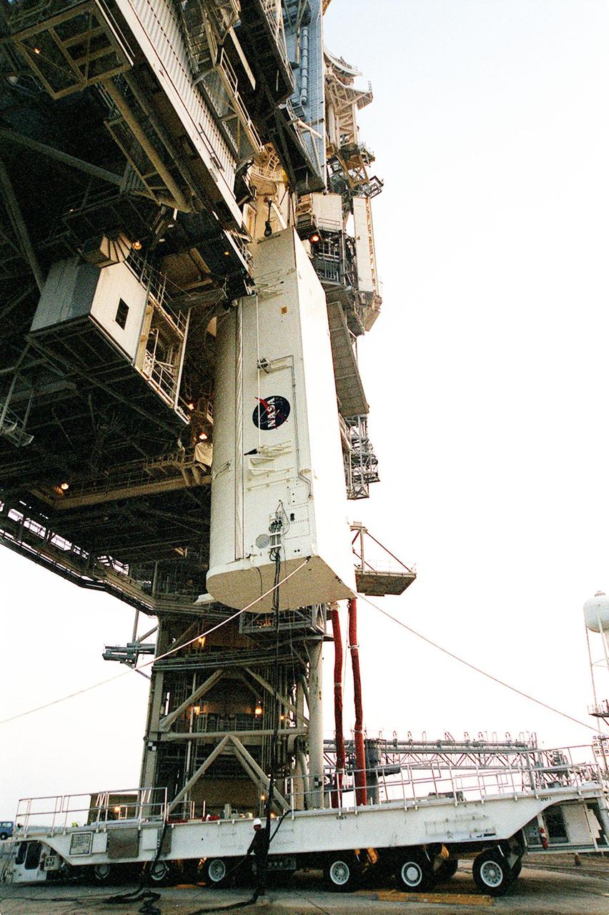 With umbilical lines still attached, the payload canister is hoisted up alongside the Rotating Service Structure (RSS) on Launch Pad 39B. The canister with its cargo of the SPACEHAB module and Integrated Cargo Carrier will be moved into the Payload Changeout Room (PCR) near the top of the RSS for transfer to the payload bay of Shuttle Atlantis for mission STS-106. The PCR provides an environmentally controlled facility for the transfer. The 11-day mission to the International Space Station will include service module support tasks on orbit, transfer supplies and outfit the Space Station for the first long-duration crew. Atlantis is scheduled to launch Sept. 8 at 8:31 a.m. EDT.
