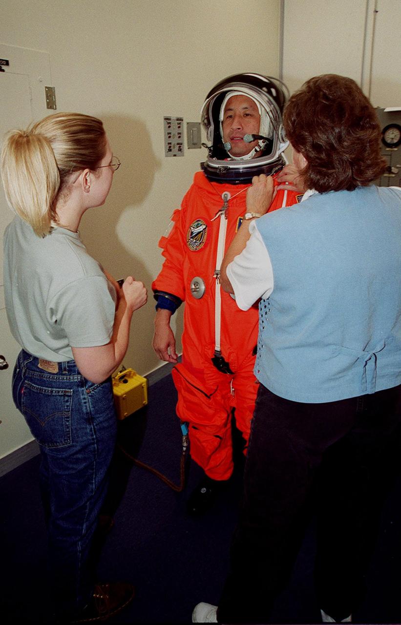 STS-106 Mission Specialist Edward T. Lu has his launch and entry suit adjusted during fit check, part of Terminal Countdown Demonstration Test activities (TCDT). The TCDT also provides emergency egress training, simulated countdown exercises and opportunities for the crew to inspect the mission payloads in the orbiter’s payload bay. STS-106 is scheduled to launch Sept. 8, 2000, at 8:31 a.m. EDT from Launch Pad 39B. On the 11-day mission, the seven-member crew will perform support tasks on orbit, transfer supplies and prepare the living quarters in the newly arrived Zvezda Service Module. The first long-duration crew, dubbed “Expedition One,” is due to arrive at the Station in late fall