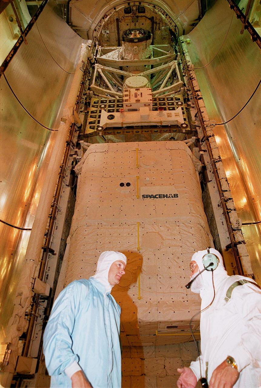 KENNEDY SPACE CENTER, FLA. -- Technicians facilitate the transfer the STS-106 payload to Atlantis on Launch Pad 39-B using the Payload Ground Handling Mechanism (PGHM). The payload within the SPACEHAB module is shown just after being loaded in the payload bay of Atlantis. The PGHM (pronounced pigem) is located inside the Payload Changeout Room (PCR) of each shuttle launch pad Rotating Service Structure. The PGHM removes payloads from a transportation canister and installs them into the orbiter. It is essentially NASA’s largest fork-lift