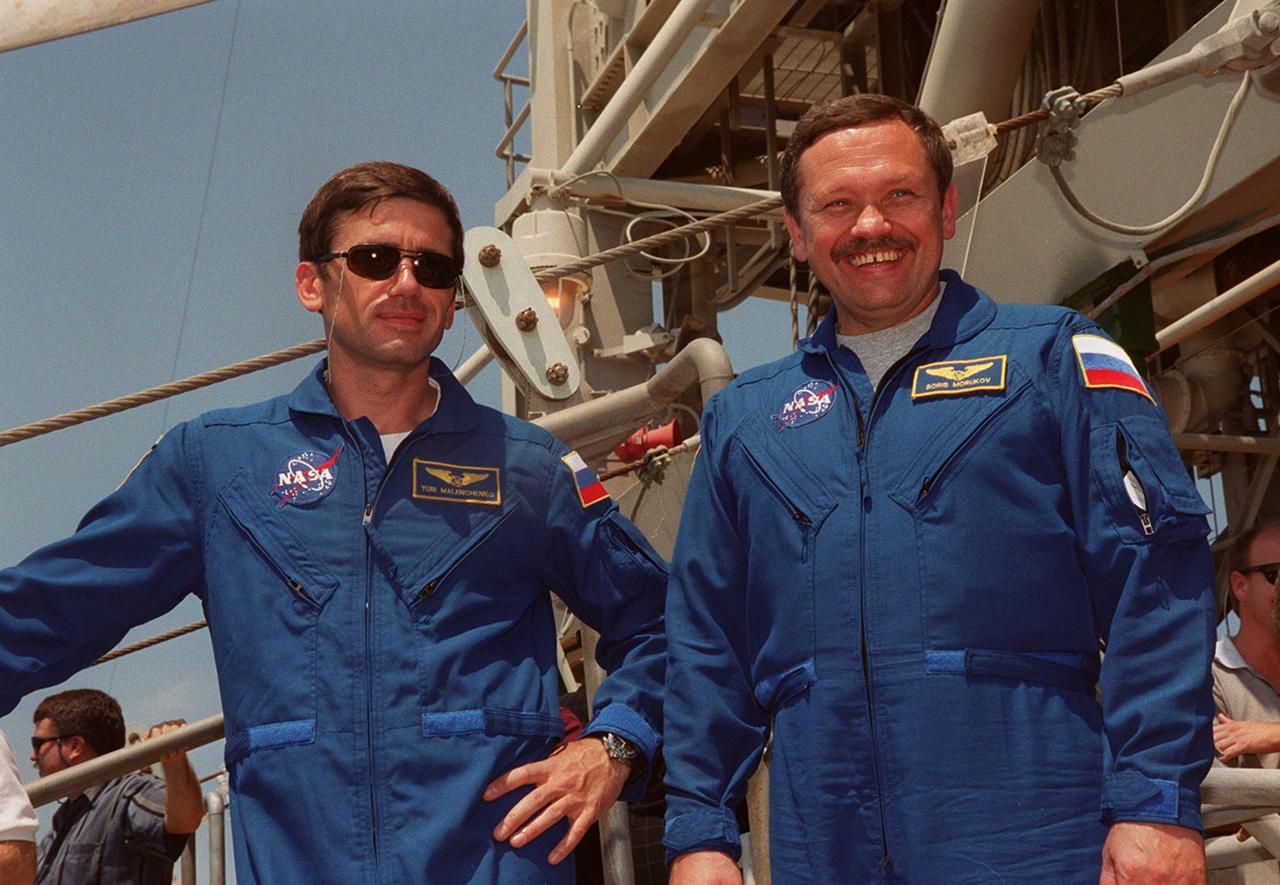 KENNEDY SPACE CENTER, Fla. --  STS-106 Mission Specialists Yuri I. Malenchenko, left, and Boris V. Morukov pause at the 195-foot level of Launch Pad 39-B. Malenchenko and Morukov are with the Russian Aviation and Space Agency. The flight crew were at Kennedy Space Center to take part in Terminal Countdown Demonstration Test (TCDT) activities. The TCDT provides the crew with emergency egress training and opportunities to inspect their mission payload in the orbiter’s payload bay. STS-106 is scheduled to launch Sept. 8, 2000, at 8:31 a.m. EDT from Launch Pad 39B. On the 11-day mission, the seven-member crew will perform support tasks on orbit, transfer supplies and prepare the living quarters in the newly arrived Zvezda Service Module. The first long-duration crew, dubbed “Expedition One,” is due to arrive at the Station in late fall