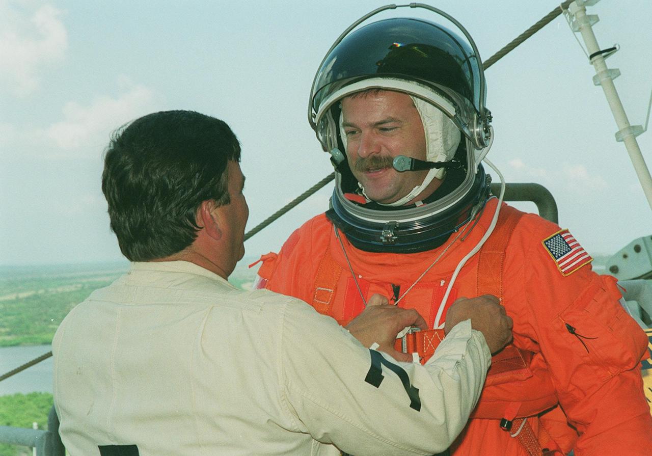KENNEDY SPACE CENTER, Fla. -- STS-106 Pilot Scott D. Altman pauses to talk to a worker after climbing out of a slidewire basket on the 195-foot level of Launch Pad 39B. The basket is part of emergency egress equipment from the pad. Altman and the STS-106 crew are taking part in Terminal Countdown Demonstration Activities (TCDT), which include emergency egress training, opportunities to inspect their mission payload in the orbiter’s payload bay, and a simulated launch countdown. STS-106 is scheduled to launch Sept. 8, 2000, at 8:31 a.m. EDT from Launch Pad 39B. On the 11-day mission, the seven-member crew will perform support tasks on orbit, transfer supplies and prepare the living quarters in the newly arrived Zvezda Service Module. The first long-duration crew, dubbed “Expedition One,” is due to arrive at the Station in late fall