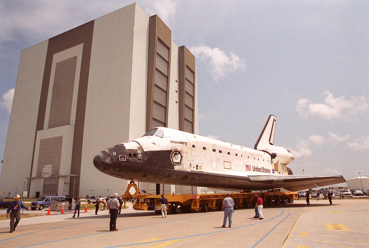 KENNEDY SPACE CENTER, FLA. -- KSC workers watch as the orbiter Discovery makes the turn around the Vehicle Assembly Building on its move from Orbiter Processing Facility (OPF) bay 1 to OPF bay 3. Ongoing payload and ground processing assessments will be completed in bay 3. Managers will then determine when to roll the orbiter to the Vehicle Assembly Building for stacking with the external tank and solid rocket boosters, and when to roll out to Launch Pad 39A. Discovery is scheduled to launch Oct. 5 at 9:30 p.m. EDT on mission STS-92, which will be the 100th flight in the Shuttle program