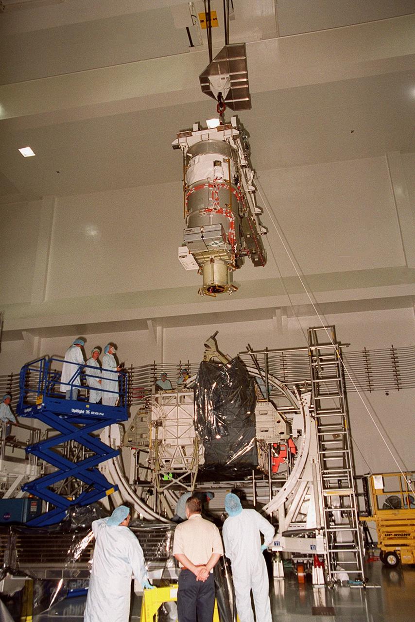 In the Space Station Processing Facility, Solar Array Wing-3 (at top), a component of the International Space Station, hovers above the Integrated Electronic Assembly where it will be installed for testing. The solar array is scheduled to be launched on STS-97 in late November along with the P6 truss. The Station’s electrical power system (EPS) will use eight photovoltaic solar arrays to convert sunlight to electricity. Each of the eight solar arrays will be 112 feet long by 39 feet wide. The solar arrays are mounted on a “blanket” that can be folded like an accordion for delivery. Once in orbit, astronauts will deploy the blankets to their full size. Gimbals will be used to rotate the arrays so that they will face the Sun to provide maximum power to the Space Station