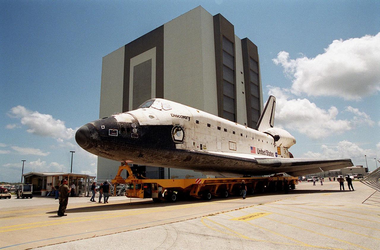 KENNEDY SPACE CENTER, FLA. -- The orbiter Discovery rolls backward out of the Orbiter Processing Facility bay 3 for transfer to the Vehicle Assembly Building (behind it), where it will be mated with its external tank and solid rocket boosters. Discovery is scheduled to launch Oct. 5 at 9:30 p.m. EDT on mission STS-92, delivering two elements of the International Space Station: the Z-1 truss and PMA-3. The launch will be the 100th flight in the Shuttle program