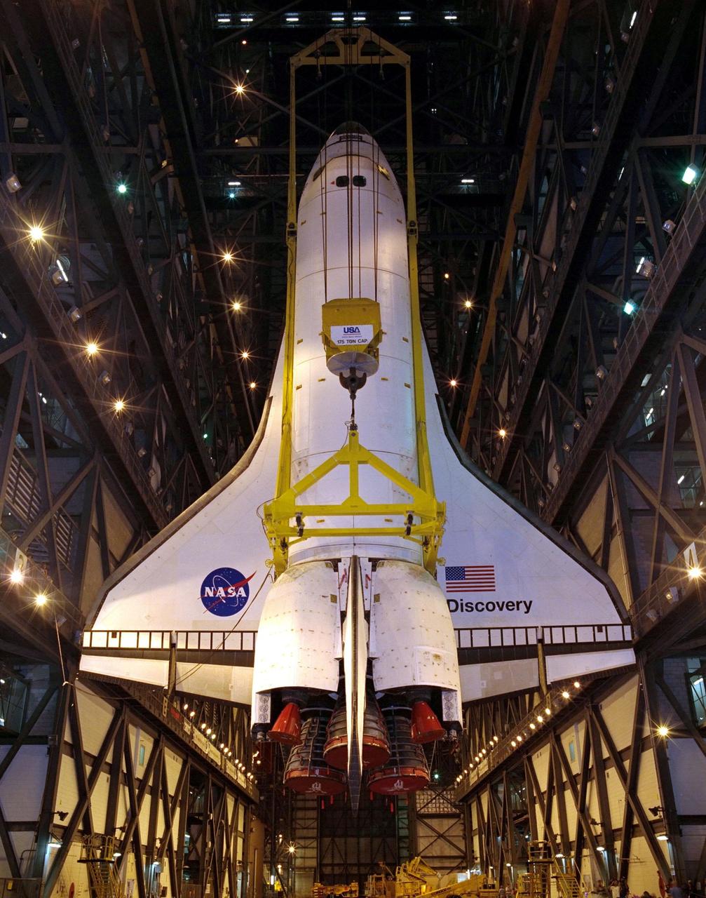 KENNEDY SPACE CENTER, FLA. -- In the transfer aisle of the Vehicle Assembly Building, an overhead crane suspends the orbiter Discovery in a vertical position before transfer to high bay 3 where it will be mated to an external tank and solid rocket boosters. Discovery is scheduled to launch Oct. 5 at 9:30 p.m. EDT on mission STS-92, delivering two elements of the International Space Station: the Z-1 truss and Pressurized Mating Adapter-3. The launch will be the 100th flight in the Shuttle program