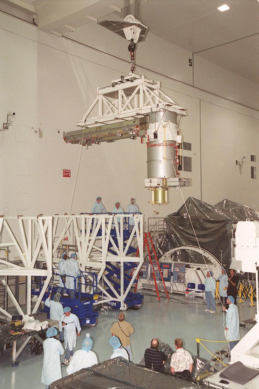 An overhead crane in the Space Station Processing Facility lifts a solar array as workers stand by to help guide it. The solar array will be installed onto the Integrated Equipment Assembly (IEA). A component of the International Space Station, the solar array is the second one being installed on the IEA. The arrays are scheduled to be launched on mission STS-97 in late November along with the P6 truss. The Station’s electrical power system (EPS) will use eight photovoltaic solar arrays to convert sunlight to electricity. Each of the eight solar arrays will be 112 feet long by 39 feet wide. The solar arrays are mounted on a “blanket” that can be folded like an accordion for delivery. Once in orbit, astronauts will deploy the blankets to their full size. Gimbals will be used to rotate the arrays so that they will face the Sun to provide maximum power to the Space Station