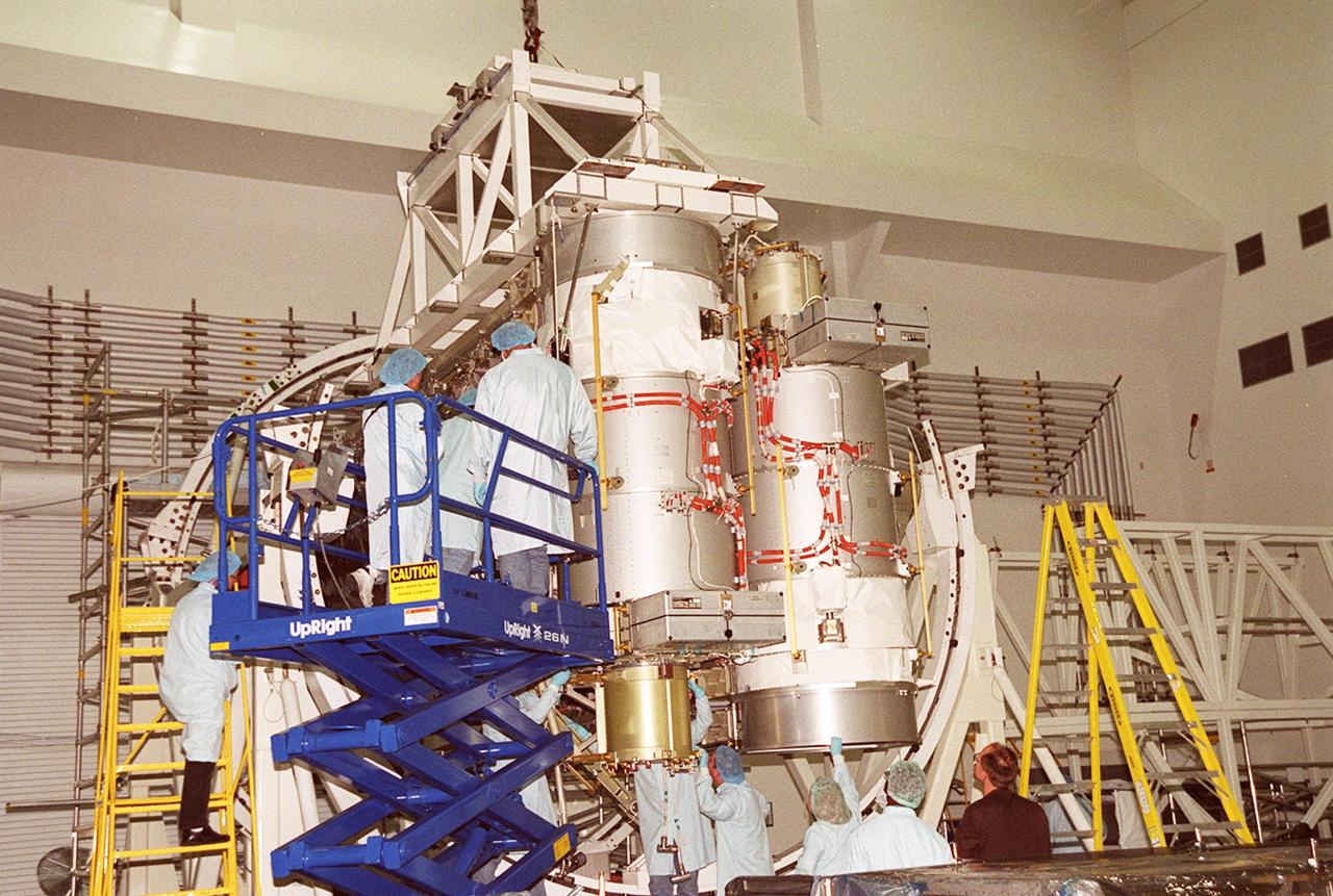 A solar array is nearly in place on the Integrated Equipment Assembly, next to Solar Array Wing-3, which is already installed. Components of the International Space Station, the arrays are scheduled to be launched on mission STS-97 in late November along with the P6 truss. The Station’s electrical power system (EPS) will use eight photovoltaic solar arrays to convert sunlight to electricity. Each of the eight solar arrays will be 112 feet long by 39 feet wide. The solar arrays are mounted on a “blanket” that can be folded like an accordion for delivery. Once in orbit, astronauts will deploy the blankets to their full size. Gimbals will be used to rotate the arrays so that they will face the Sun to provide maximum power to the Space Station