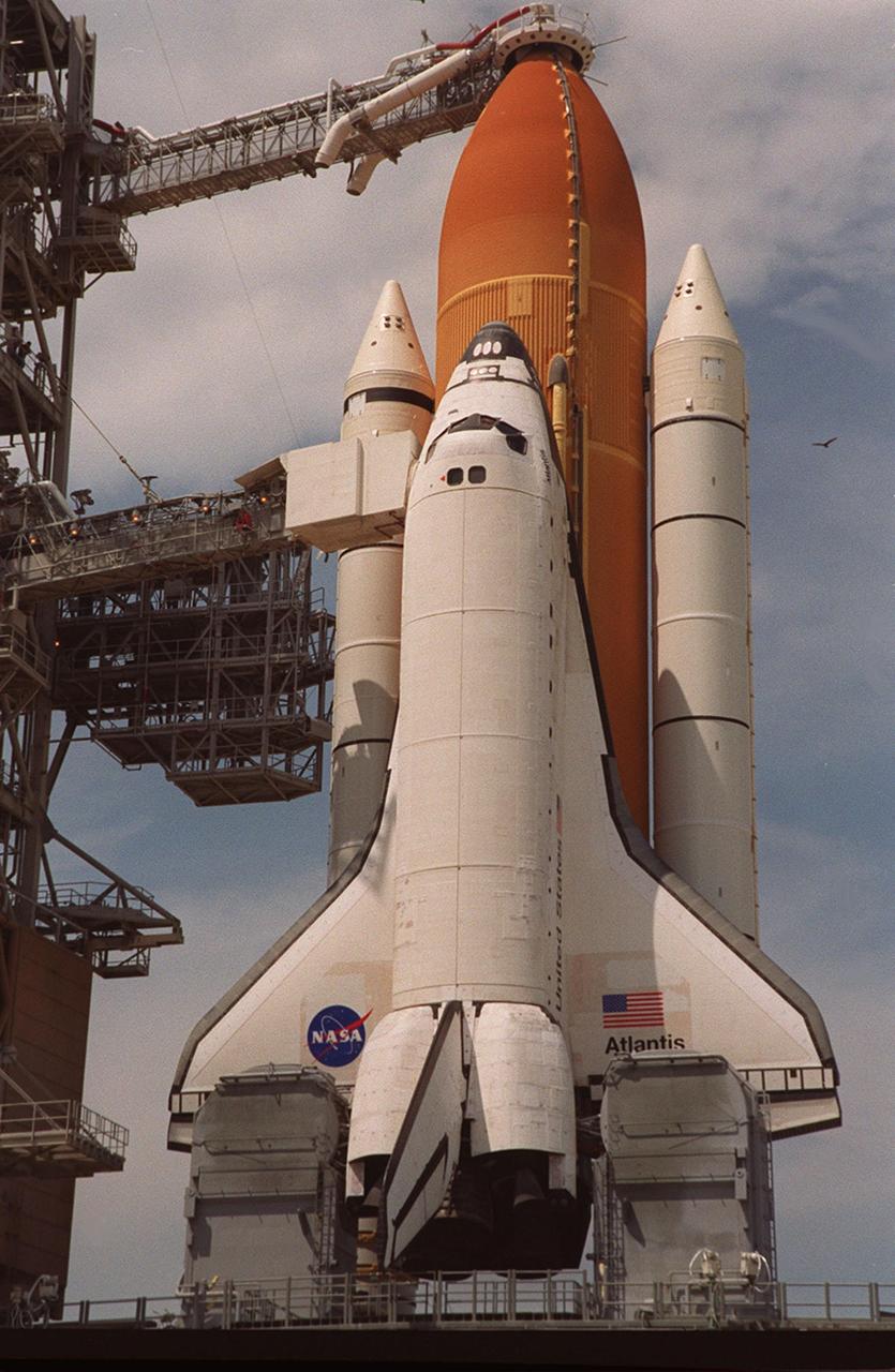 KENNEDY SPACE CENTER, Fla. -- Clouds hover overhead the Space Shuttle Atlantis after rollback of the Rotating Service Structure. On top of the external tank is the 13-foot-wide “beanie cap,” at the end of the Gaseous Oxygen Vent Arm, designed to vent gaseous oxygen vapors away from the Space Shuttle. Lower is the Orbiter Access Arm with the environmental chamber, known as the “white room,” extended to the orbiter. The chamber provides entry for the crew into the orbiter and also serves as emergency egress up to 7 minutes 24 seconds before launch. Ready for launch of mission STS-106 at 8:45 a.m. EDT on Sept. 8, Atlantis carries supplies to prepare the Russian Zvezda living quarters on the International Space Station for the first long-duration crew. The crew will also be transferring supplies from the Russian Progress resupply ship already docked to the aft of Zvezda. The fourth U.S. launch for the Space Station, the mission is expected to last 10 days, 19 hours and 9 minutes, landing at KSC 4:59 a.m. EDT on Sept. 19