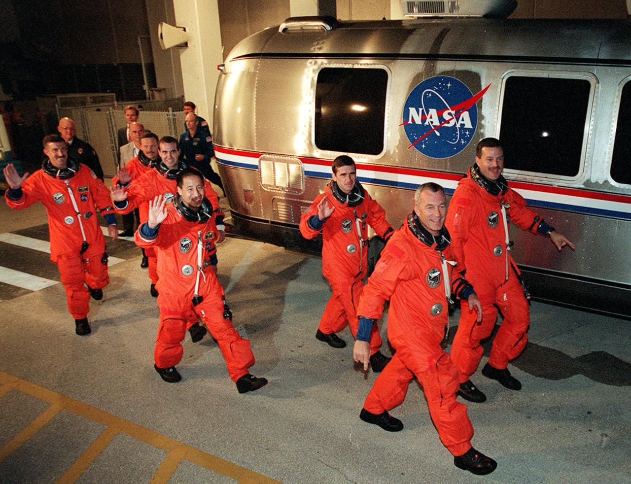 The STS-106 crew wave to onlookers as they rush to the Astrovan that will take them to Launch Pad 39B. From left to right are Mission Specialists Daniel C. Burbank, Boris V. Morukov, Richard A. Mastracchio, Edward T. Lu and Yuri I. Malenchenko; Commander Terrence W. Wilcutt; and Pilot Scott D. Altman. Liftoff of Space Shuttle Atlantis is set for 8:45 a.m. EDT on the fourth flight to the International Space Station. On the 11-day mission, the seven-member crew will perform support tasks on orbit, transfer supplies and prepare the living quarters in the newly arrived Zvezda Service Module. The first long-duration crew, dubbed “Expedition One,” is due to arrive at the Station in late fall