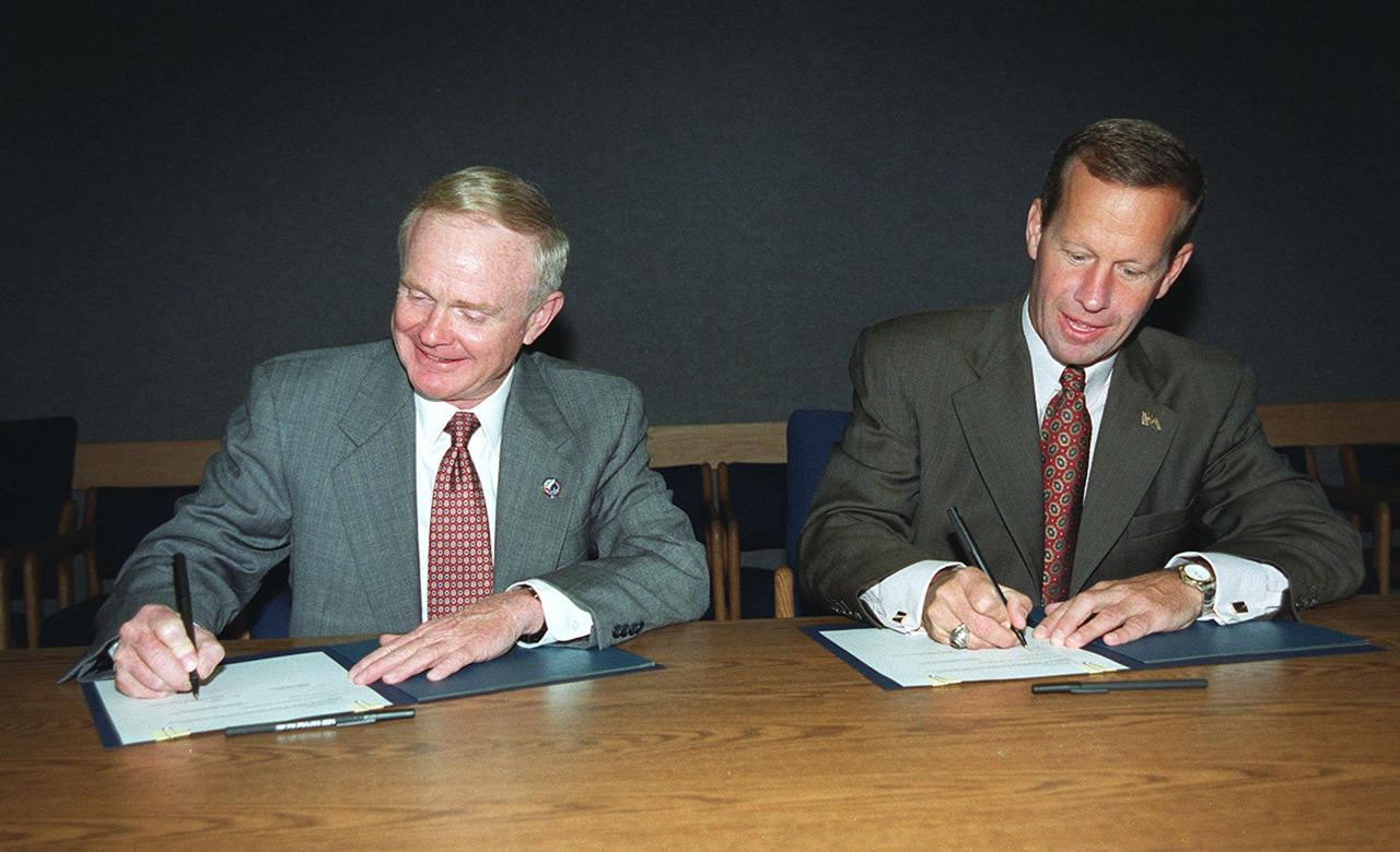 At the KSC Visitor Complex, Center Director Roy D. Bridges (left) and Florida’s Lieutenant Governor Frank T. Brogan sign a Memorandum of Understanding (MOU). The MOU documents the intent of NASA KSC and the State of Florida to form partnerships with academic institutions in Florida for development of aerospace-related advanced training and academic/educational programs. The three-year project anticipates that the partnership and educational programs fostered will improve the lifelong learning environment for the aerospace and engineering workforce