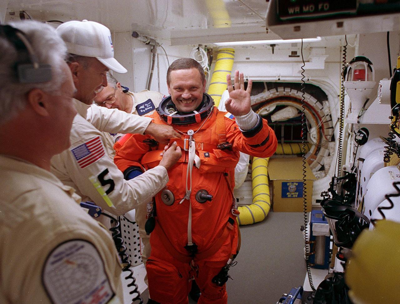 STS-106 Mission Specialist Boris V. Morukov waves as a suit technician in the White Room helps him with his launch and entry suit before he enters Space Shuttle Atlantis. The opening into Atlantis can be seen in the background. The perfect on-time liftoff of Atlantis on mission STS-106 occurred at 8:45:47 a.m. EDT. On the 11-day mission to the International Space Station, the seven-member crew will perform support tasks on orbit, transfer supplies and prepare the living quarters in the newly arrived Zvezda Service Module. The first long-duration crew, dubbed “Expedition One,” is due to arrive at the Station in late fall. Landing of Atlantis is targeted for 4:45 a.m. EDT on Sept. 19