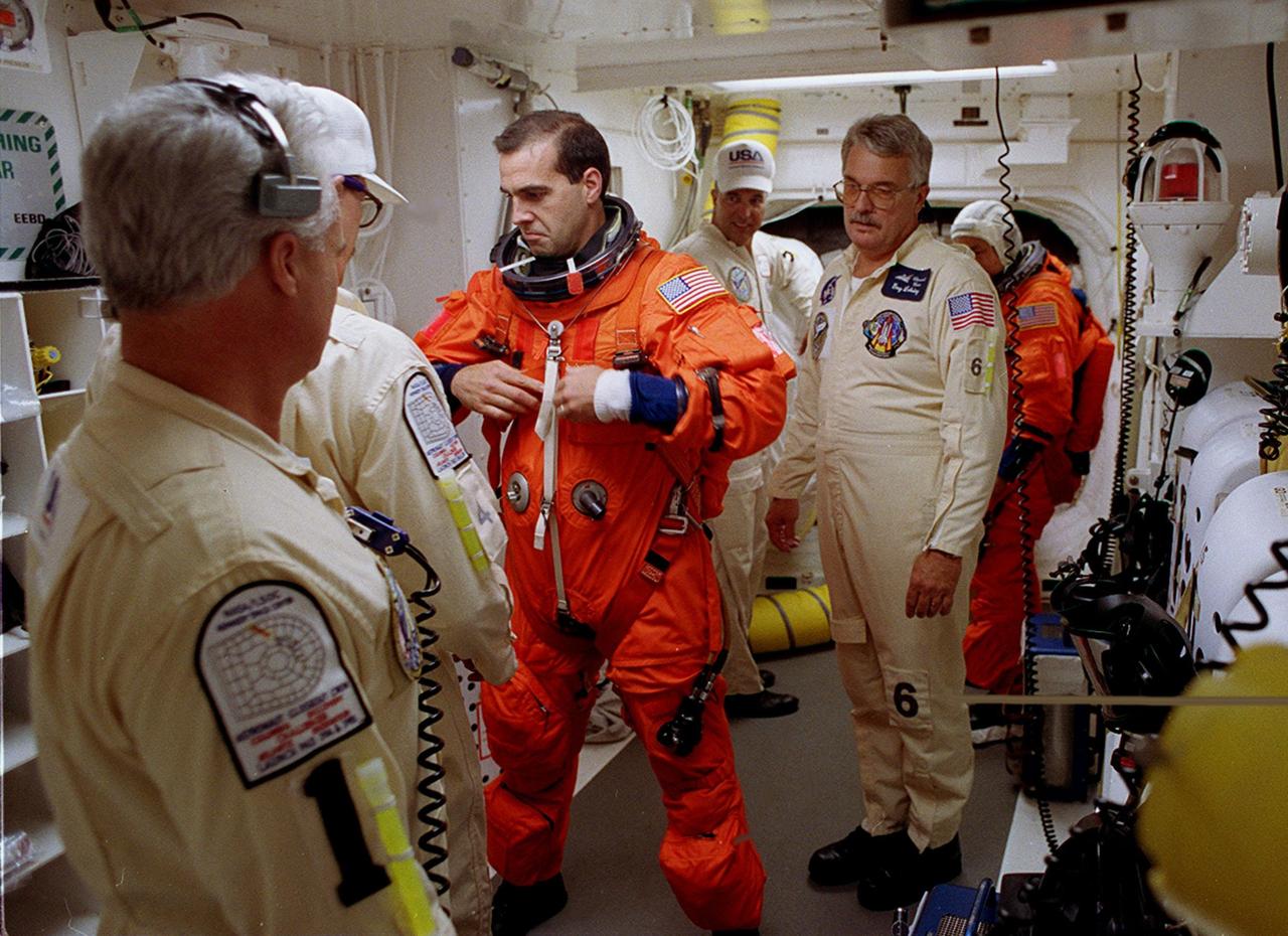 STS-106 Mission Specialist Richard A. Mastracchio is helped with his launch and entry suit in the White Room before entering Space Shuttle Atlantis. The perfect on-time liftoff of Atlantis on mission STS-106 occurred at 8:45:47 a.m. EDT. On the 11-day mission to the International Space Station, the seven-member crew will perform support tasks on orbit, transfer supplies and prepare the living quarters in the newly arrived Zvezda Service Module. The first long-duration crew, dubbed “Expedition One,” is due to arrive at the Station in late fall. Landing of Atlantis is targeted for 4:45 a.m. EDT on Sept. 19