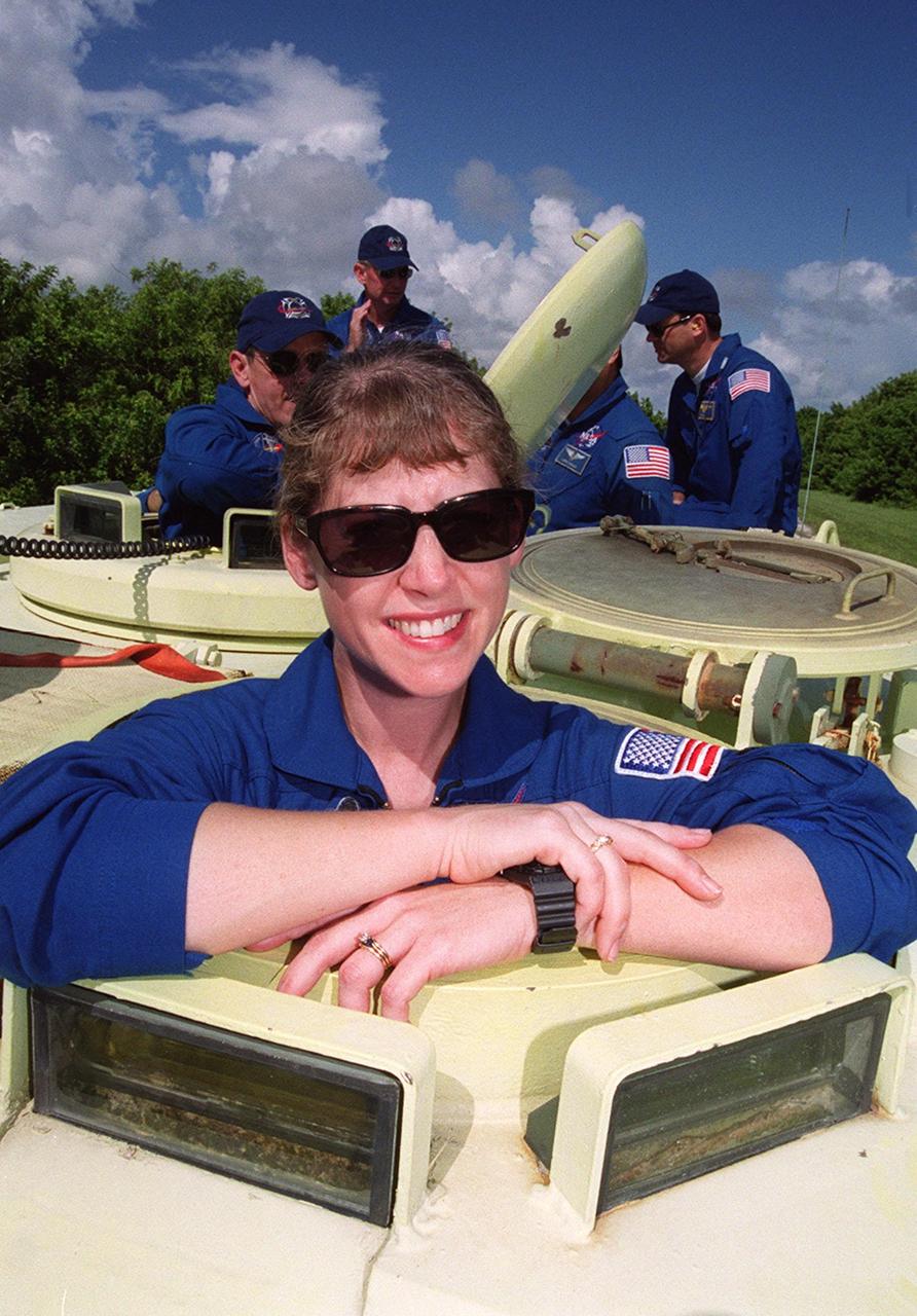 STS-92 Pilot Pam Melroy is ready to take her turn driving the M-113, part of emergency egress training during Terminal Countdown Demonstration Test (TCDT) activities. Behind her, waiting to take their turn, are (left to right) Mission Specialist Jeff Wisoff, Commander Brian Duffy, and Mission Specialists Bill McArthur and Michael Lopez-Alegria. The tracked vehicle could be used by the crew in the event of an emergency at the pad during which the crew must make a quick exit from the area. The TCDT also provides simulated countdown exercises and opportunities to inspect the mission payloads in the orbiter’s payload bay. STS-92 is scheduled to launch Oct. 5 at 9:30 p.m. EDT on the fifth flight to the International Space Station. It will carry two elements of the Space Station, the Integrated Truss Structure Z1 and the third Pressurized Mating Adapter. The mission is also the 100th flight in the Shuttle program