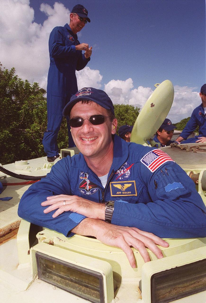 STS-92 Mission Specialist Jeff Wisoff happily anticipates his chance to drive the M-113 he is in. Behind him are Commander Brian Duffy (left) and Mission Specialist Leroy Chiao, along with other crew members. Part of emergency egress training during Terminal Countdown Demonstration Test (TCDT) activities, the tracked vehicle could be used by the crew in the event of an emergency at the pad during which the crew must make a quick exit from the area. The TCDT also provides simulated countdown exercises and opportunities to inspect the mission payloads in the orbiter’s payload bay. STS-92 is scheduled to launch Oct. 5 at 9:30 p.m. EDT on the fifth flight to the International Space Station. It will carry two elements of the Space Station, the Integrated Truss Structure Z1 and the third Pressurized Mating Adapter. The mission is also the 100th flight in the Shuttle program
