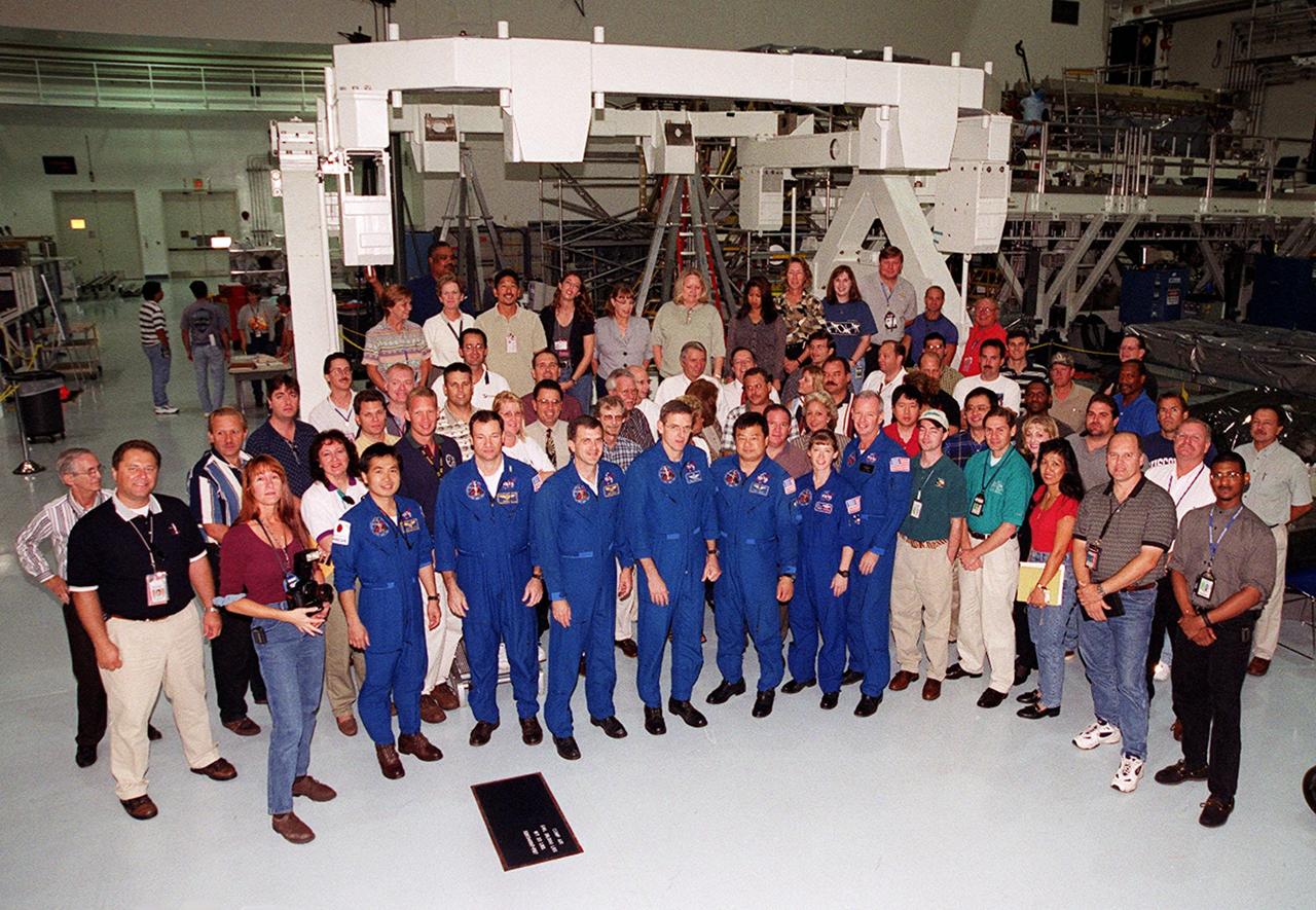 In the Space Station Processing Facility, workers who have supported mission STS-92 gather for a photo with the crew: (left to right) Mission Specialists Koichi Wakata of Japan, Michael Lopez-Alegria, Jeff Wisoff, Bill McArthur and Leroy Chiao; Pilot Pam Melroy; and Commander Brian Duffy. STS-92 is scheduled to launch Oct. 5 at 9:30 p.m. EDT on the fifth flight to the International Space Station. It will carry two elements of the Space Station, the Integrated Truss Structure Z1 and the third Pressurized Mating Adapter. The mission is also the 100th flight in the Shuttle program