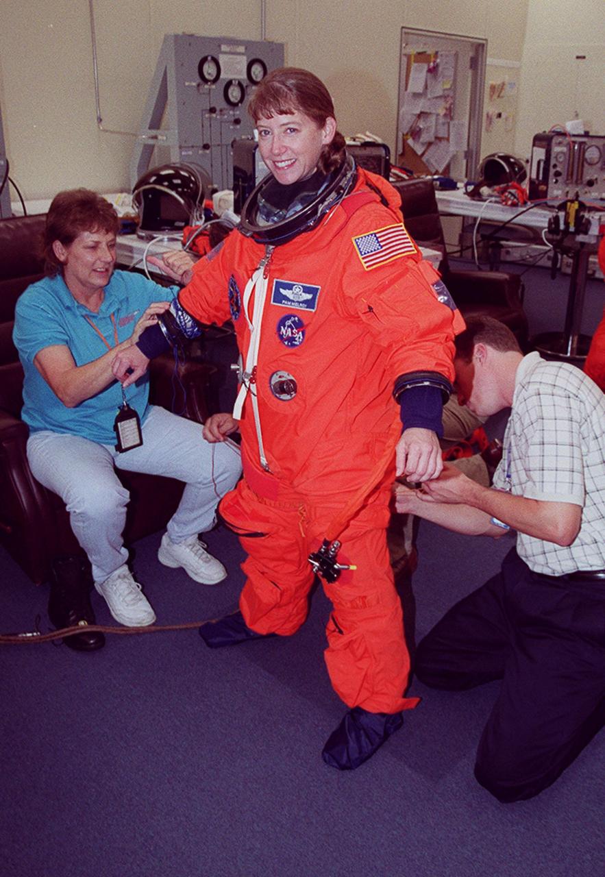 The “rookie” on the STS-92 mission, Pilot Pamela Ann Melroy has her new launch and entry suit adjusted during pre-pack and fit check in the Operations and Checkout Building. Melroy and the rest of the crew are at KSC for Terminal Countdown Demonstration Test activities. The TCDT provides emergency egress training, simulated countdown exercises and opportunities to inspect the mission payload. STS-92 is scheduled to launch Oct. 5 at 9:38 p.m. EDT from Launch Pad 39A on the fifth flight to the International Space Station. It will carry two elements of the Space Station, the Integrated Truss Structure Z1 and the third Pressurized Mating Adapter. The mission is also the 100th flight in the Shuttle program
