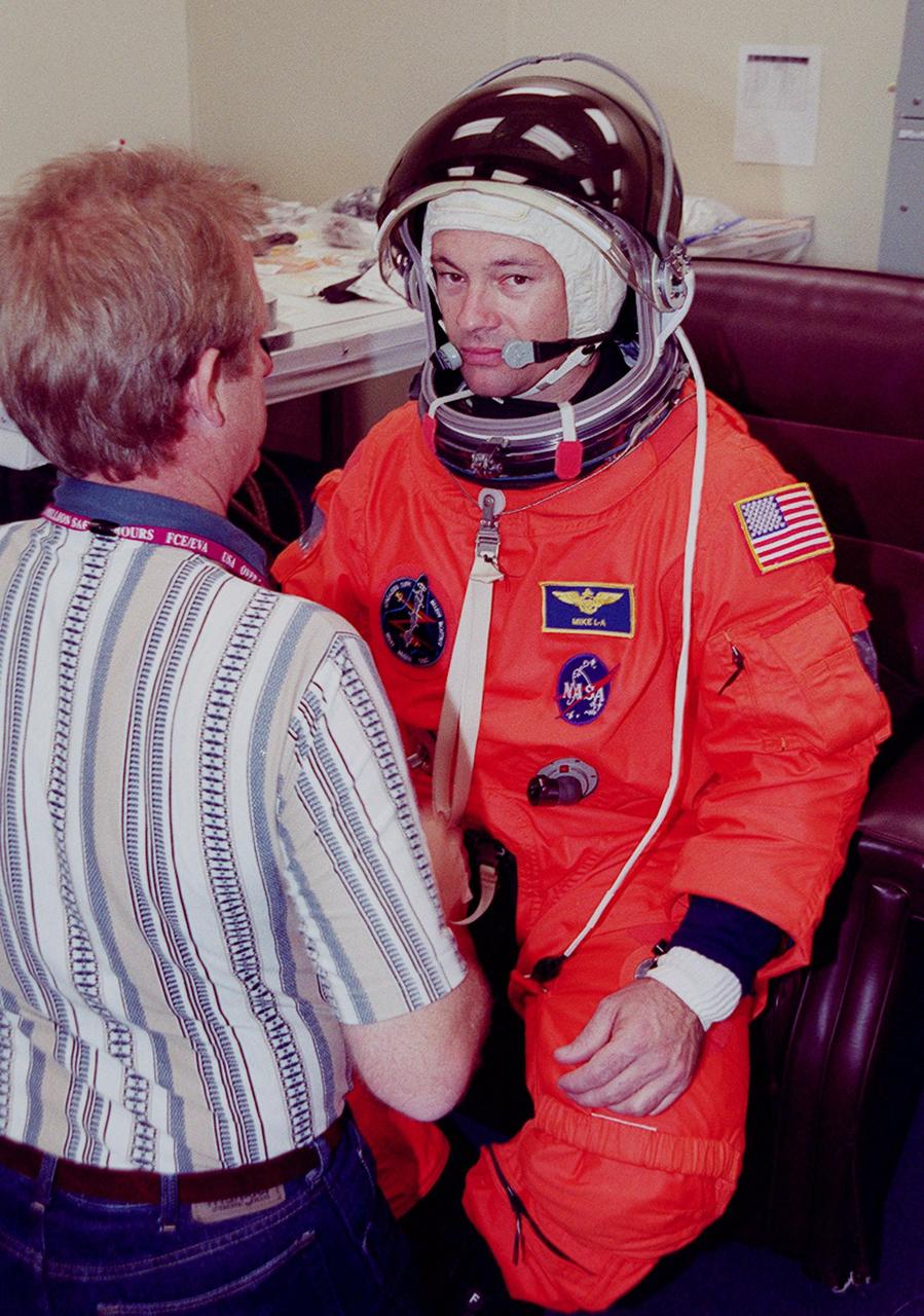 During pre-pack and fit check in the Operations and Checkout Building, STS-92 Mission Specialist Michael E. Lopez-Alegria tries on the helmet for his launch and entry suit. Lopez-Alegria and the rest of the crew are at KSC for Terminal Countdown Demonstration Test activities. The TCDT provides emergency egress training, simulated countdown exercises and opportunities to inspect the mission payload. This mission will be Lopez-Alegria’s second Shuttle flight. STS-92 is scheduled to launch Oct. 5 at 9:38 p.m. EDT from Launch Pad 39A on the fifth flight to the International Space Station. It will carry two elements of the Space Station, the Integrated Truss Structure Z1 and the third Pressurized Mating Adapter. The mission is also the 100th flight in the Shuttle program