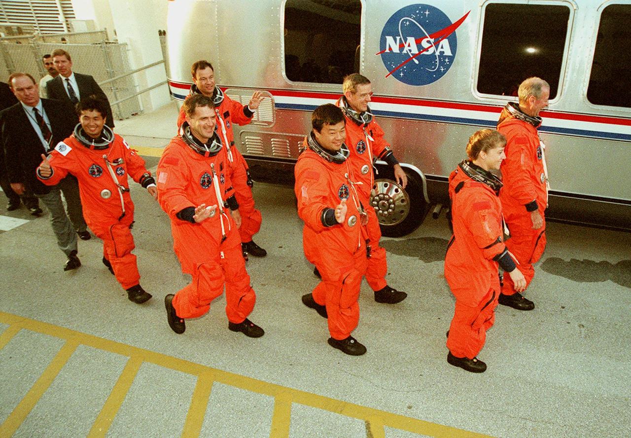 The STS-92 crew exits the Operations and Checkout Building on their way to the Astrovan and Launch Pad 39A for a simulated countdown. Walking left to right are (foreground) Mission Specialists Koichi Wakata of Japan, Peter J.K. “Jeff” Wisoff and Leroy Chiao; and Pilot Pamela Ann Melroy. Behind them are Mission Specialists Michael E. Lopez-Alegria and William S. McArthur Jr.; and Commander Brian Duffy. The crew is taking part in Terminal Countdown Demonstration Test activities that provide emergency egress training, opportunities to inspect the mission payload, and the simulated countdown. STS-92 is scheduled to launch Oct. 5 at 9:38 p.m. EDT on the fifth flight to the International Space Station. It will carry two elements of the Space Station, the Integrated Truss Structure Z1 and the third Pressurized Mating Adapter. The mission is also the 100th flight in the Shuttle program
