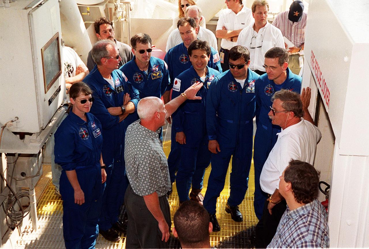 At the 195-foot level of the Fixed Service Structure on Launch Pad 39A, the STS-92 crew get instructions on using the emergency egress equipment. Standing left to right, in uniform, are Pilot Pamela Ann Melroy, Commander Brian Duffy and Mission Specialists Peter J.K. “Jeff” Wisoff, Michael E. Lopez-Alegria, Koichi Wakata of Japan, Leroy Chiao and William S. McArthur Jr. The training is part of Terminal Countdown Demonstration Test activities that also provide opportunities to inspect the mission payload and take part in a simulated countdown. STS-92 is scheduled to launch Oct. 5 at 9:38 p.m. EDT on the fifth flight to the International Space Station. It will carry two elements of the Space Station, the Integrated Truss Structure Z1 and the third Pressurized Mating Adapter. The mission is also the 100th flight in the Shuttle program