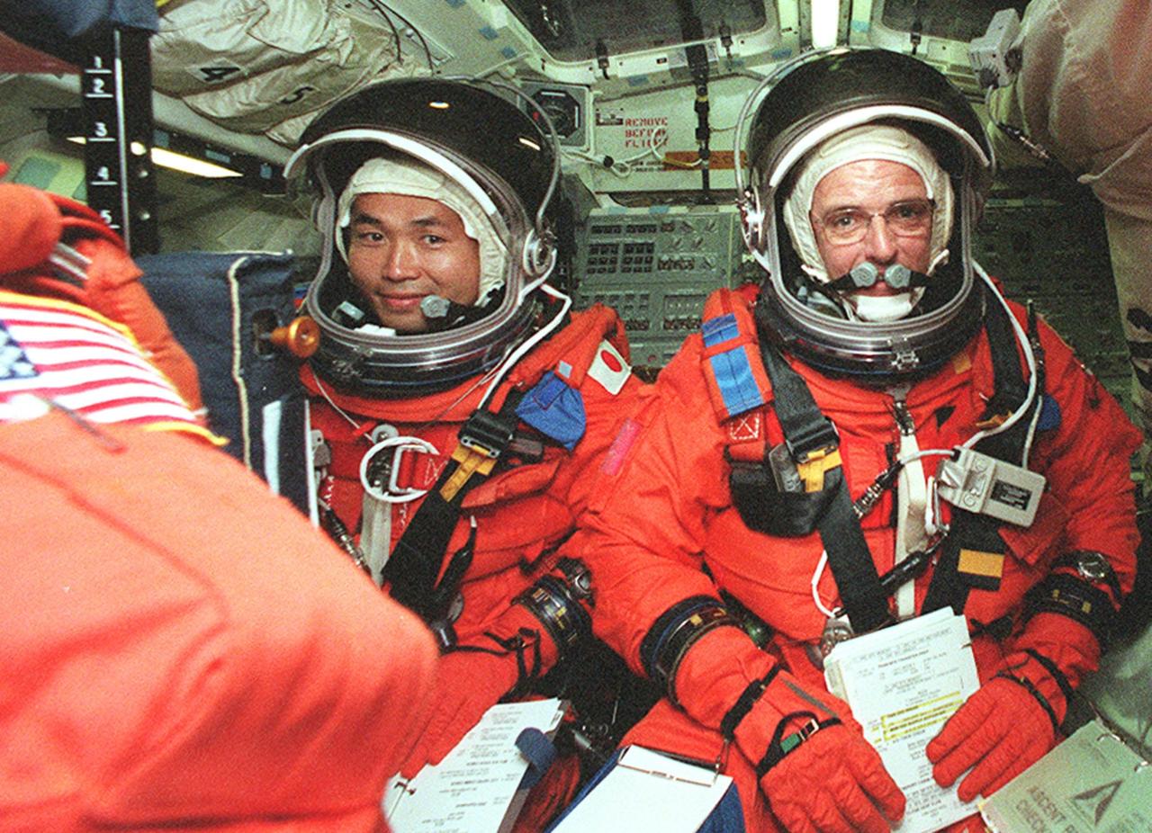 KENNEDY SPACE CENTER, FLA. -- STS-92 Mission Specialists Koichi Wakata of Japan (left) and William S. McArthur Jr. (right) get settled in their seats in Discovery for a simulated countdown. The countdown is part of Terminal Countdown Demonstration Test (TCDT) activities that he and other crew members have been performing. STS-92 is scheduled to launch Oct. 5 at 9:38 p.m. EDT on the fifth flight to the International Space Station. It will carry two elements of the Space Station, the Integrated Truss Structure Z1 and the third Pressurized Mating Adapter. The mission is also the 100th flight in the Shuttle program