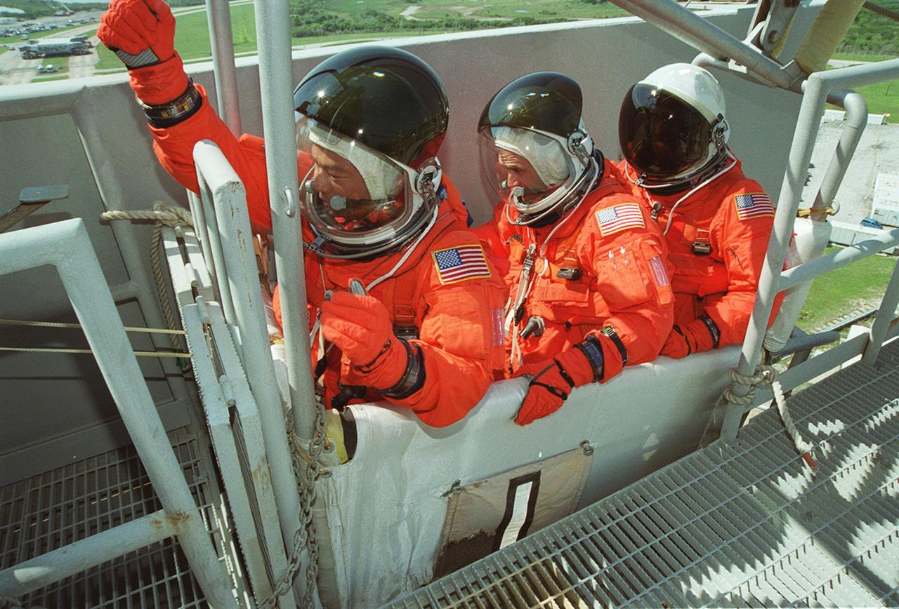 KENNEDY SPACE CENTER, FLA. -- Seated in the slidewire basket at the 195-foot level of the Fixed Service Structure on Launch Pad 39A, STS-92 Mission Specialists Leroy Chiao, Peter J.K. “Jeff” Wisoff and Michael E. Lopez-Alegria practice emergency egress. They and other crew members have been taking part in Terminal Countdown Demonstration Test activities that also include a simulated countdown. STS-92 is scheduled to launch Oct. 5 at 9:38 p.m. EDT on the fifth flight to the International Space Station. It will carry two elements of the Space Station, the Integrated Truss Structure Z1 and the third Pressurized Mating Adapter. The mission is also the 100th flight in the Shuttle program