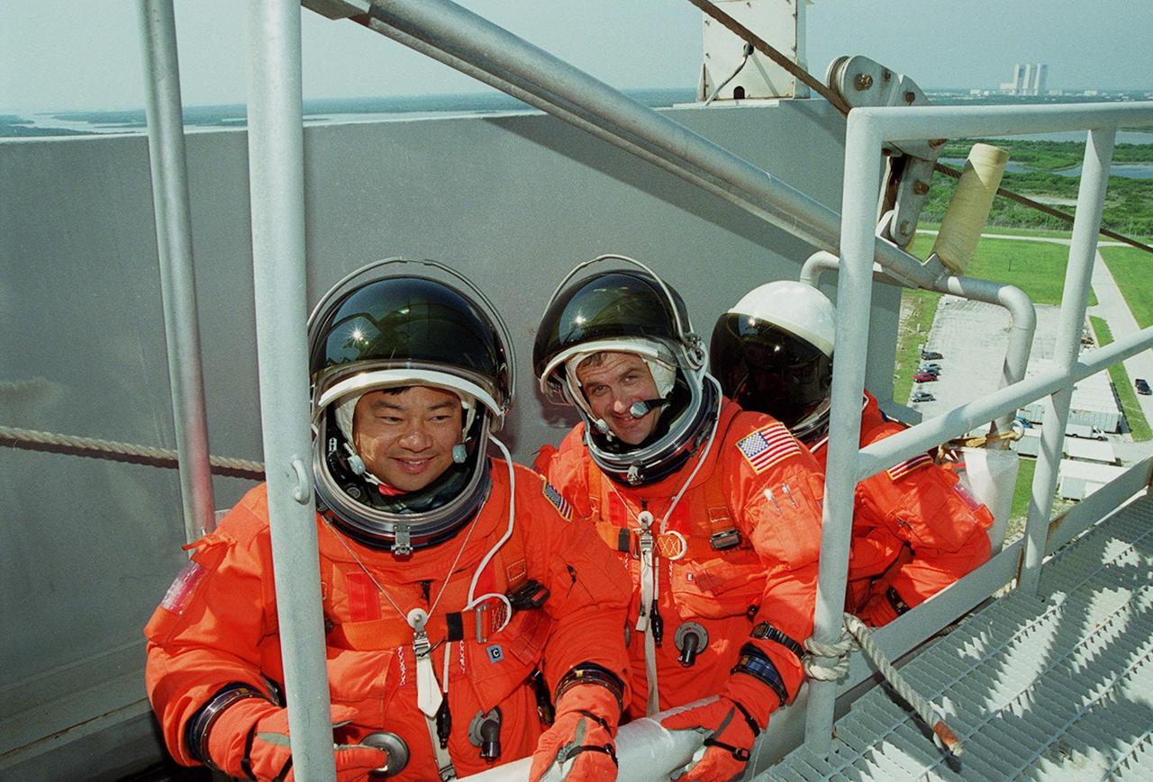 KENNEDY SPACE CENTER, FLA. -- Seated in the slidewire basket at the 195-foot level of the Fixed Service Structure on Launch Pad 39A, STS-92 Mission Specialists Leroy Chaio, Peter J.K. “Jeff” Wisoff and Michael E. Lopez-Alegria take part in emergency egress training, one of the Terminal Countdown Demonstration Test activities that also include a simulated countdown. STS-92 is scheduled to launch Oct. 5 at 9:38 p.m. EDT on the fifth flight to the International Space Station. It will carry two elements of the Space Station, the Integrated Truss Structure Z1 and the third Pressurized Mating Adapter. The mission is also the 100th flight in the Shuttle program