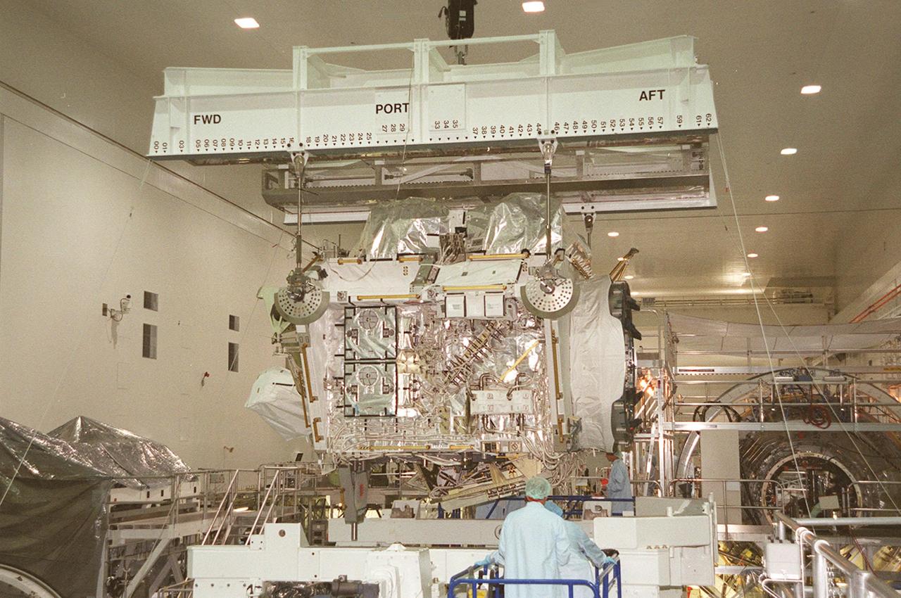 In the Space Station Processing Facility, the Integrated Truss Structure Z1, an element of the International Space Station, is lifted for moving to another stand to check its weight and balance. The Z1 truss is the first of 10 trusses that will become the backbone of the Space Station, eventually stretching the length of a football field. Along with its companion payload, the third Pressurized Mating Adapter, the Z1 is scheduled to be launched aboard Space Shuttle Discovery Oct. 5 at 9:38 p.m. EDT. The launch will be the 100th in the Shuttle program