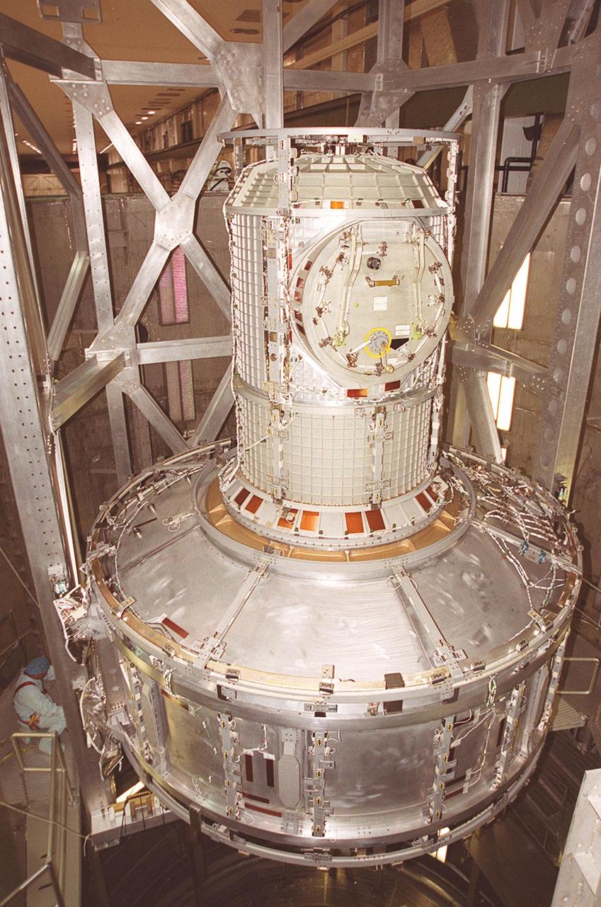 Workers inside the vacuum chamber in the Operations and Checkout Building watch as an overhead crane lowers the Joint Airlock Module inside. The airlock is being tested for leaks. The module is the gateway from which crew members aboard the International Space Station (ISS) will enter and exit the 470-ton orbiting research facility. The airlock is a critical element of the ISS because of design differences between American and Russian spacesuits. The Joint Airlock Module provides a chamber where astronauts from every nation can suit up for space walks to conduct maintenance and construction work or to do science experiments outside the Station. The Space Shuttle Atlantis will carry the airlock to orbit on mission STS-104, the 10th International Space Station flight, currently targeted for liftoff in May 2001. The Shuttle crew will secure the airlock to the right side of Unity, the American-built connecting node that currently comprises one-third of the current Space Station, along with the Russian modules Zarya and Zvezda