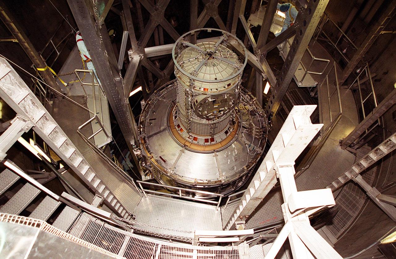 The Joint Airlock Module is fully lowered into the vacuum chamber inside the Operations and Checkout Building. Workers on either side check its position. The airlock is being tested for leaks. The module is the gateway from which crew members aboard the International Space Station (ISS) will enter and exit the 470-ton orbiting research facility. The airlock is a critical element of the ISS because of design differences between American and Russian spacesuits. The Joint Airlock Module provides a chamber where astronauts from every nation can suit up for space walks to conduct maintenance and construction work or to do science experiments outside the Station. The Space Shuttle Atlantis will carry the airlock to orbit on mission STS-104, the 10th International Space Station flight, currently targeted for liftoff in May 2001. The Shuttle crew will secure the airlock to the right side of Unity, the American-built connecting node that currently comprises one-third of the current Space Station, along with the Russian modules Zarya and Zvezda