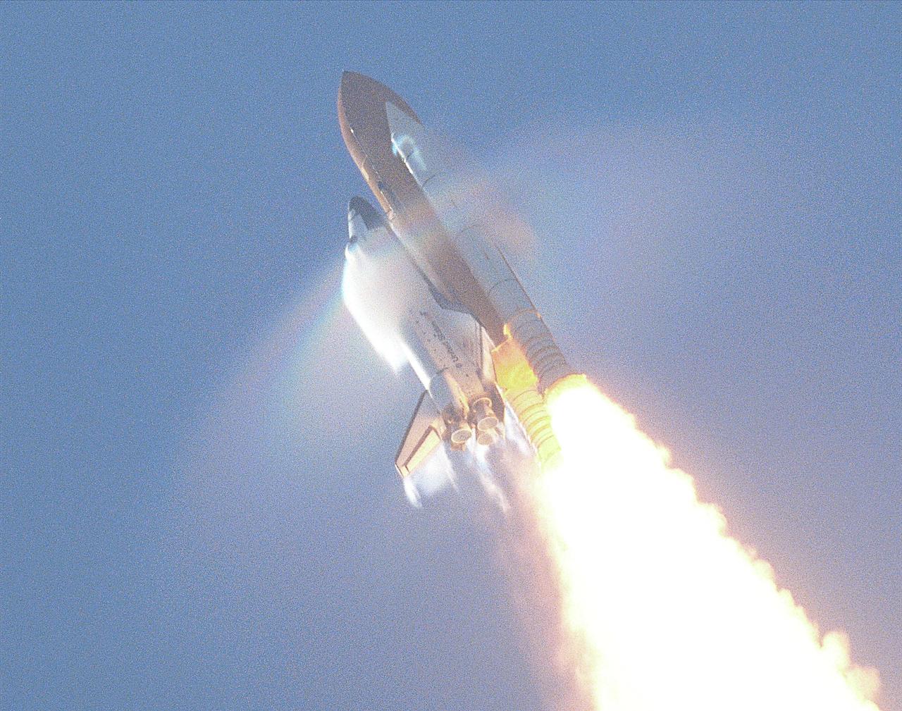KENNEDY SPACE CENTER, FLA. -- This view of the shock wave condensation collars backlit by the sun occurred during the launch of Atlantis on STS-106 and was captured on an engineering 35mm motion picture film. One frame was digitized to make this still image. Although the primary effect is created by the Orbiter forward fuselage, secondary effects can be seen on the SRB forward skirt, Orbiter vertical stabilizer and wing trailing edges (behind SSME's).