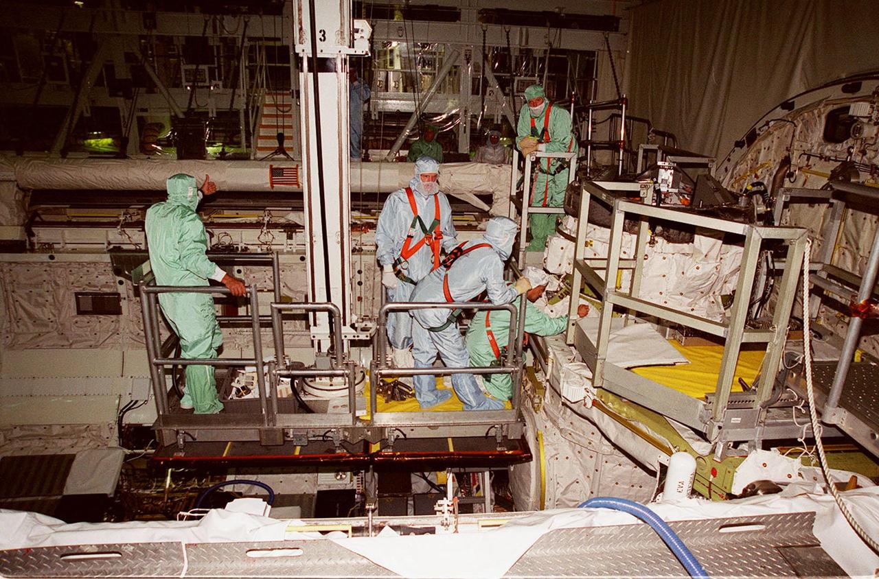 KENNEDY SPACE CENTER, FLA. -- In Orbiter Processing Facility (OPF) bay 2 during Crew Equipment Interface Test (CEIT), members of the STS-97 crew look over the Orbital Docking System in Endeavour’s payload bay. In the center, standing, is Mission Specialist Joe Tanner. Kneeling (at right) is Mission Specialist Carlos Noriega. The others are workers in the OPF. The CEIT provides an opportunity for crew members to check equipment and facilities that will be on board the orbiter during their mission. The STS-97 mission will be the sixth construction flight to the International Space Station. The payload includes a photovoltaic (PV) module, providing solar power to the Station. STS-97 is scheduled to launch Nov. 30 from KSC for the 10-day mission