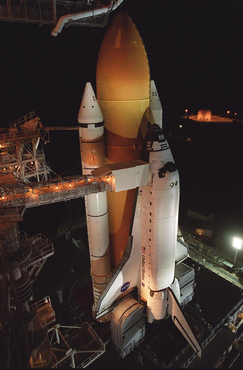 KENNEDY SPACE CENTER, Fla. --  With the Rotating Service Structure rolled back, Space Shuttle Discovery is revealed on the Mobile Launcher Platform at Launch Pad 39A. Discovery is being readied for the STS-92 mission launch to the International Space Station (ISS). At the top is the 13-foot-wide “beanie cap,” at the end of the Gaseous Oxygen Vent Arm, designed to vent gaseous oxygen vapors away from the Space Shuttle. Lower is the Orbiter Access Arm with the environmental chamber, known as the “white room,” extended to the orbiter. The chamber provides entry for the crew into the orbiter and also serves as emergency egress up to 7 minutes 24 seconds before launch. The STS-92 mission payload includes Integrated Truss Structure Z-1, an early exterior framework to allow the first U.S. solar arrays on a future flight to be temporarily installed on Unity for early power; Ku-band communication to support early science capability and U.S. television; and the third Pressurized Mating Adapter to provide a Shuttle docking port for solar array installation on the sixth ISS flight and Lab installation on the seventh ISS flight. The 11-day mission will include four spacewalks. Liftoff is scheduled for Oct. 6 at 9:16 p.m. EDT