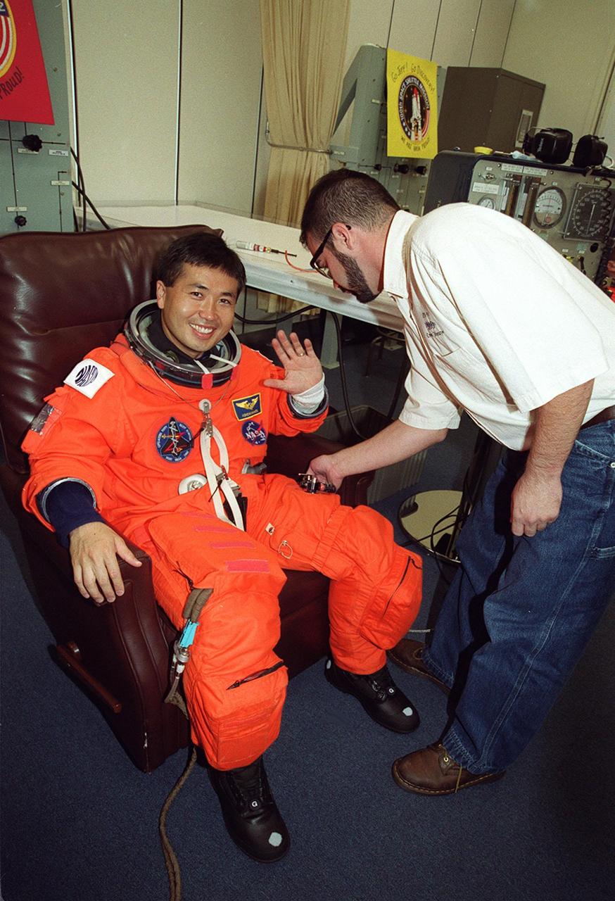 STS-92 Mission Specialist Koichi Wakata of Japan waves while his launch and entry suit is checked during suitup for launch, scheduled for 8:05 p.m. EDT. The mission is the fifth flight for the construction of the ISS. The payload includes the Integrated Truss Structure Z-1 and the third Pressurized Mating Adapter. During the 11-day mission, four extravehicular activities (EVAs), or spacewalks, are planned. The Z-1 truss is the first of 10 that will become the backbone of the International Space Station, eventually stretching the length of a football field. PMA-3 will provide a Shuttle docking port for solar array installation on the sixth ISS flight and Lab installation on the seventh ISS flight. This launch is the second for Wakata. Landing is expected Oct. 21 at 3:55 p.m. EDT