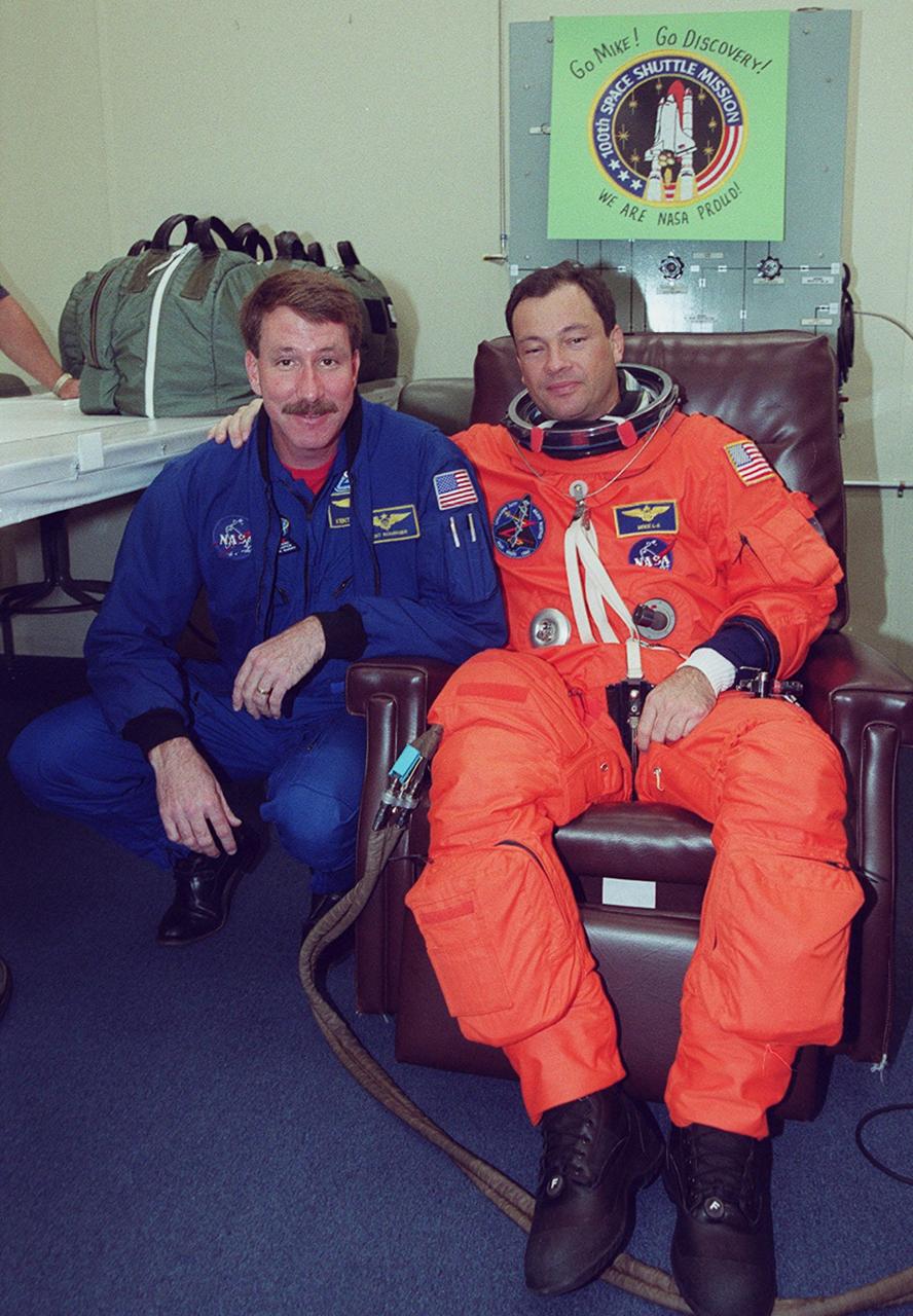 STS-92 Mission Specialist Michael E. Lopez-Alegria (right) is visited by astronaut Kent Rominger (left), who was recently named Commander of the STS-100 mission. Lopez-Alegria is getting suited up for launch on mission STS-92, scheduled for 8:05 p.m. EDT. The mission is the fifth flight for the construction of the ISS. The payload includes the Integrated Truss Structure Z-1 and the third Pressurized Mating Adapter. During the 11-day mission, four extravehicular activities (EVAs), or spacewalks, are planned. The Z-1 truss is the first of 10 that will become the backbone of the International Space Station, eventually stretching the length of a football field. PMA-3 will provide a Shuttle docking port for solar array installation on the sixth ISS flight and Lab installation on the seventh ISS flight. This launch is the second for Lopez-Alegria. Landing is expected Oct. 21 at 3:55 p.m. EDT