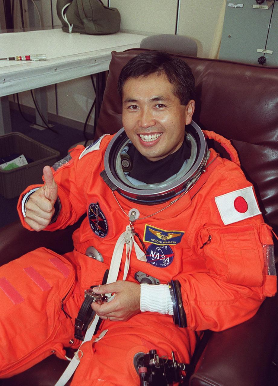 During suitup in the Operations and Checkout Building, STS-92 Mission Specialist Koichi Wakata of Japan signals thumbs up for a second launch attempt. During the 11-day mission to the International Space Station, four extravehicular activities (EVAs), or spacewalks, are planned for construction. The payload includes the Integrated Truss Structure Z-1 and the third Pressurized Mating Adapter. The Z-1 truss is the first of 10 that will become the backbone of the Space Station, eventually stretching the length of a football field. PMA-3 will provide a Shuttle docking port for solar array installation on the sixth Station flight and Lab installation on the seventh Station flight.; Launch is scheduled for 7:17 p.m. EDT. Landing is expected Oct. 22 at 2:10 p.m. EDT
