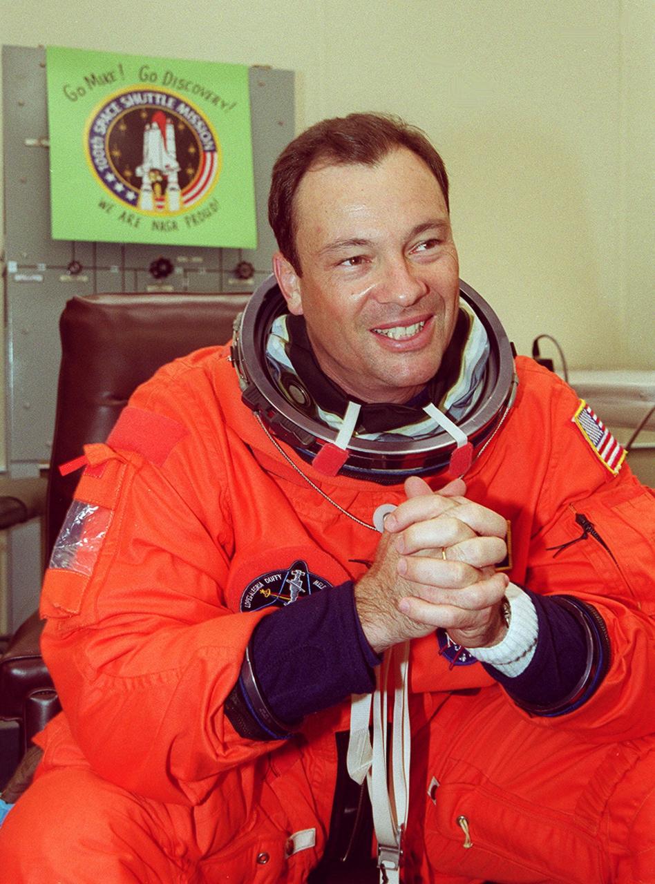During suitup in the Operations and Checkout Building, STS-92 Mission Specialist Michael E. Lopez-Alegria smiles and clasps his hands in anticipation of a second launch attempt. He and the rest of the crew will be heading out to the Astrovan for the ride to Launch Pad 39A. During the 11-day mission to the International Space Station, four extravehicular activities (EVAs), or spacewalks, are planned for construction. The payload includes the Integrated Truss Structure Z-1 and the third Pressurized Mating Adapter. The Z-1 truss is the first of 10 that will become the backbone of the Space Station, eventually stretching the length of a football field. PMA-3 will provide a Shuttle docking port for solar array installation on the sixth Station flight and Lab installation on the seventh Station flight. Launch is scheduled for 7:17 p.m. EDT. Landing is expected Oct. 22 at 2:10 p.m. EDT