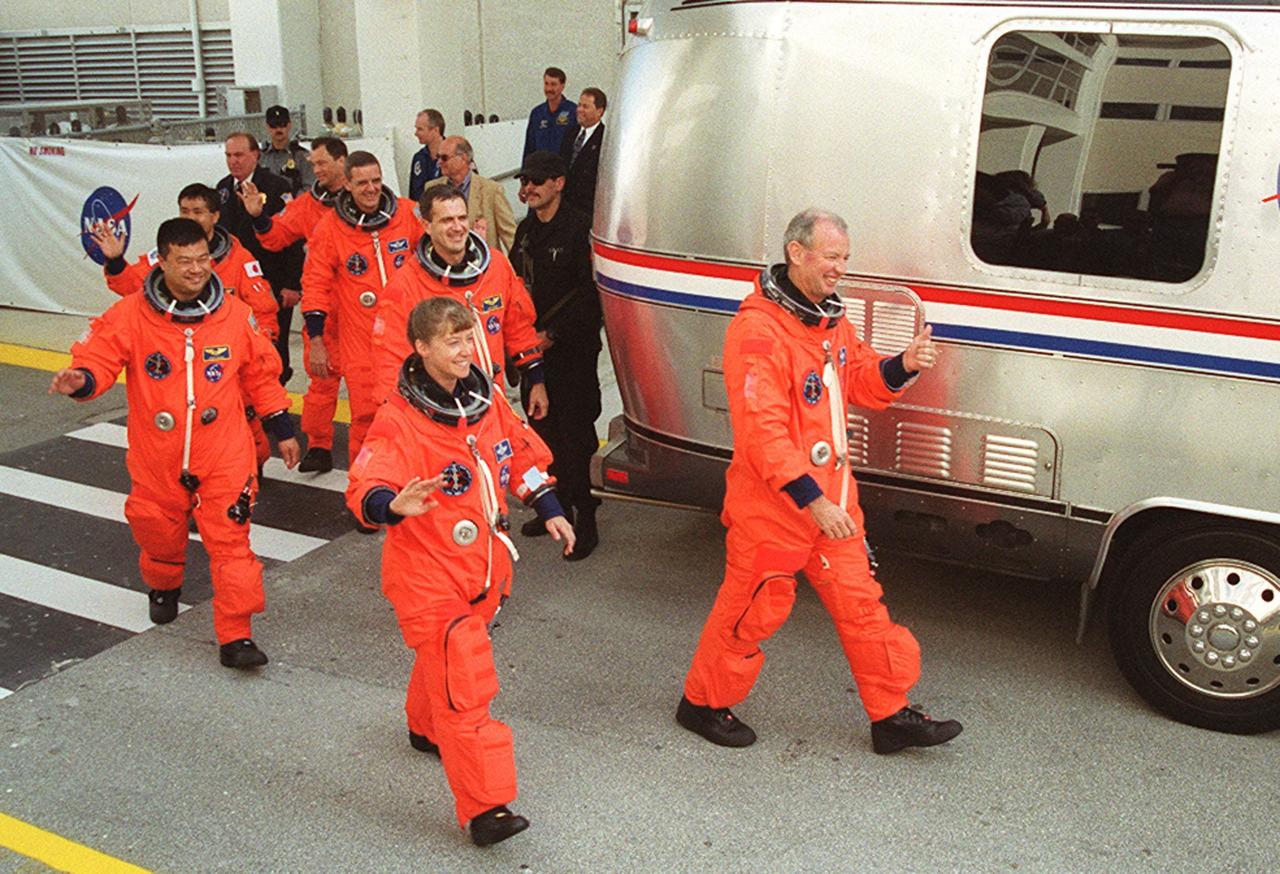 Smiling and waving at photographers and onlookers, the STS-92 crew hurries to the waiting Astrovan for the trip to Launch Pad 39A and liftoff of Space Shuttle Discovery. Clockwise from right, leading the way are Commander Brian Duffy and Pilot Pamela Ann Melroy; then Mission Specialists Leroy Chiao, Koichi Wakata of Japan, Michael Lopez-Alegria, William S. McArthur Jr. and Peter J.K. “Jeff” Wisoff. During the 11-day mission to the International Space Station, four extravehicular activities (EVAs), or spacewalks, are planned for construction. The payload includes the Integrated Truss Structure Z-1 and the third Pressurized Mating Adapter. The Z-1 truss is the first of 10 that will become the backbone of the Space Station, eventually stretching the length of a football field. PMA-3 will provide a Shuttle docking port for solar array installation on the sixth Station flight and Lab installation on the seventh Station flight. This launch is the fourth for Duffy and Wisoff, the third for Chiao and McArthur, second for Wakata and Lopez-Alegria, and first for Melroy. Launch is scheduled for 7:17 p.m. EDT. Discovery’s landing is expected Oct. 22 at 2:10 p.m. EDT