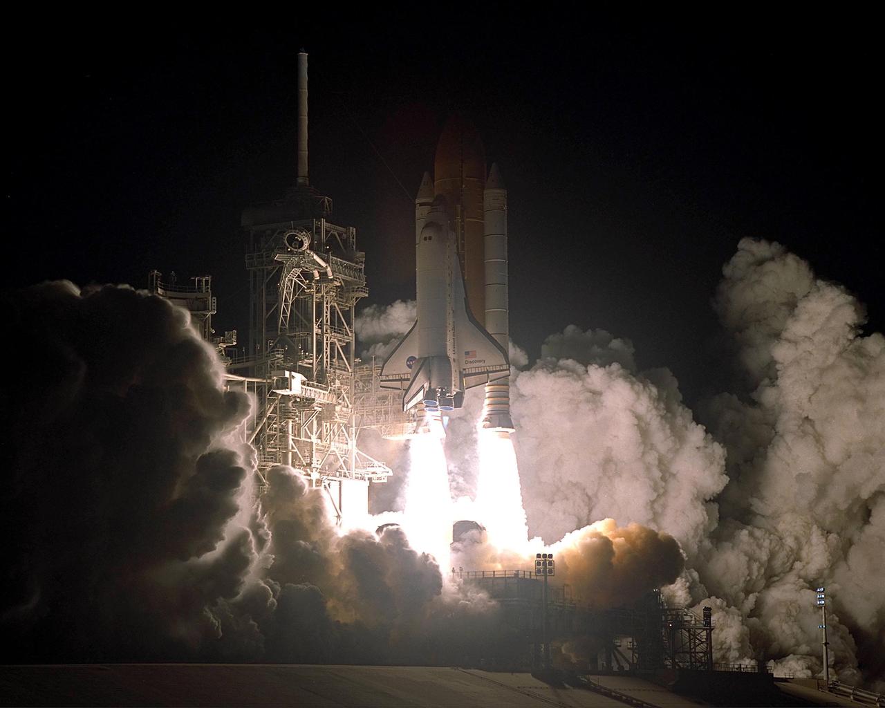 KENNEDY SPACE CENTER, Fla. -- Twin columns of flame from the solid rocket boosters illuminate the clouds of smoke and steam as Space Shuttle Discovery lifts off on mission STS-92, the fifth construction flight for the International Space Station. The perfect on-time liftoff occurred at 7:17 p.m. EDT, sending a crew of seven on the 100th launch in the history of the Shuttle program. Discovery carries a payload that includes the Integrated Truss Structure Z-1, first of 10 trusses that will form the backbone of the Space Station, and the third Pressurized Mating Adapter that will provide a Shuttle docking port for solar array installation on the sixth Station flight and Lab installation on the seventh Station flight. Discovery’s landing is expected Oct. 22 at 2:10 p.m. EDT